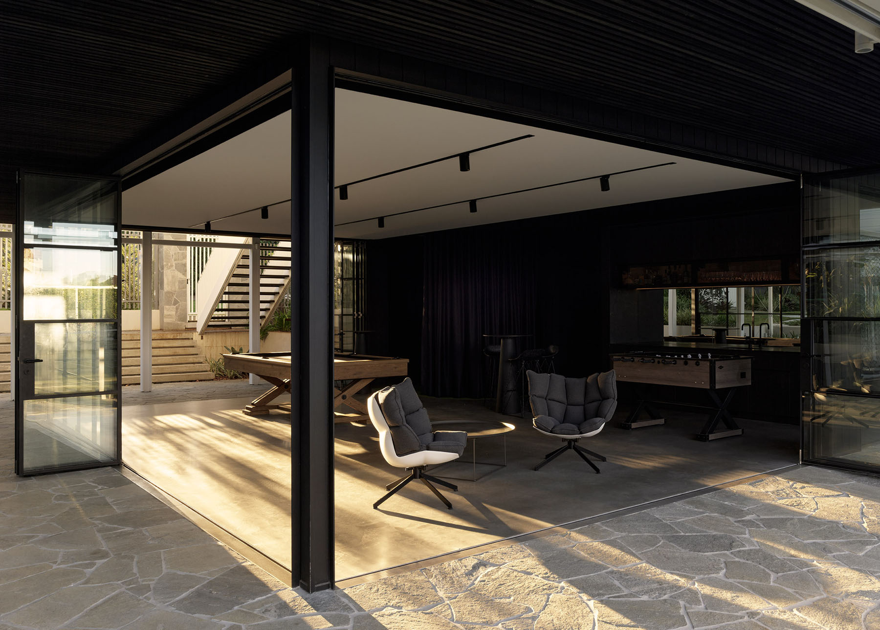indoor-outdoor living area with open pavilion, seating and games space