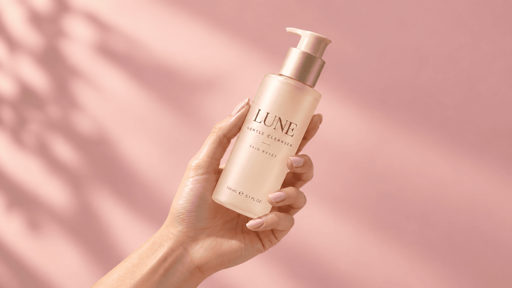 LUNE Gentle Cleanser held against a soft pink background