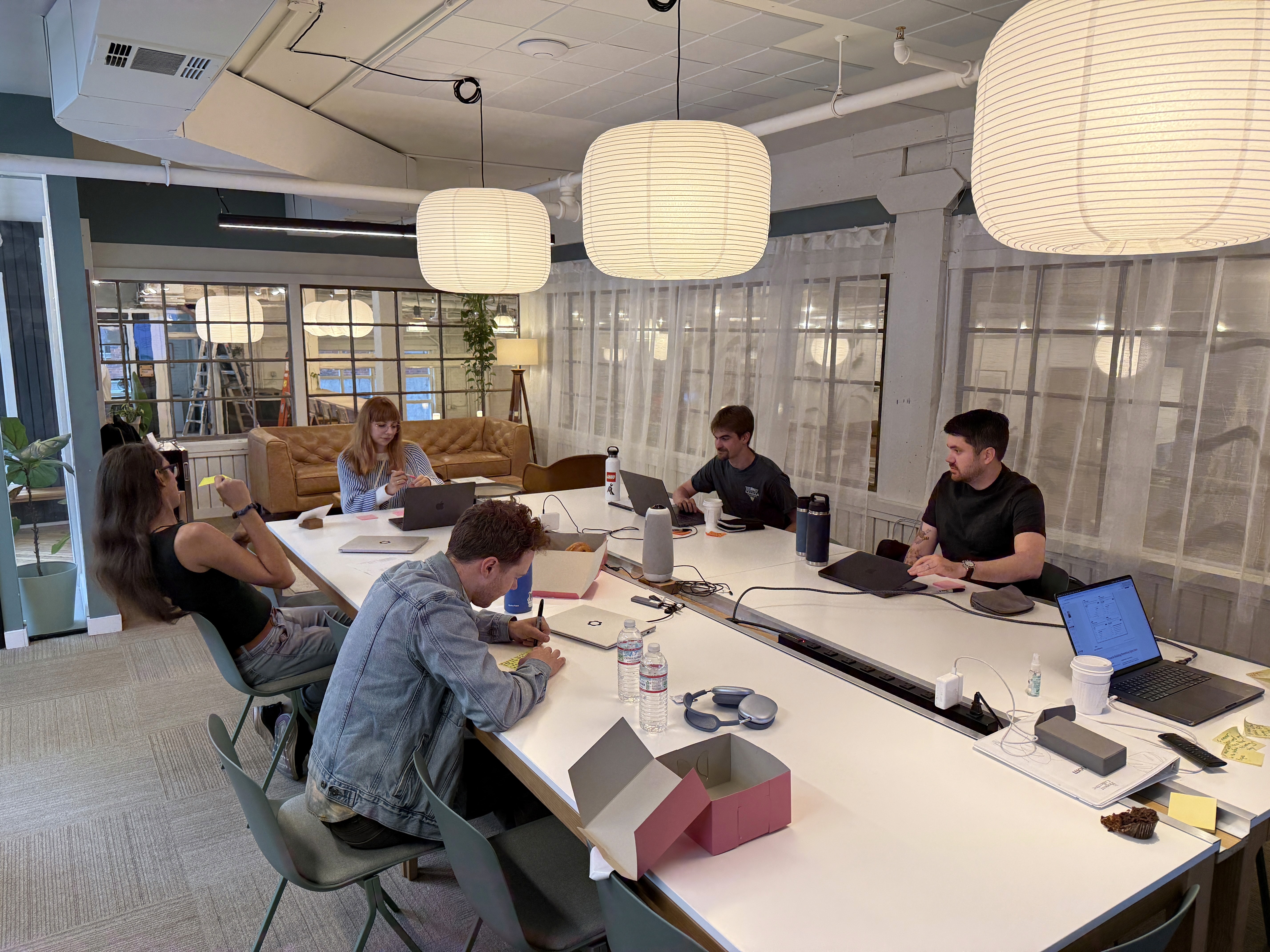 Five professionals sitting inside a meeting