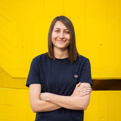 A person on a white shirt and black coat standing at the window indoor of the office