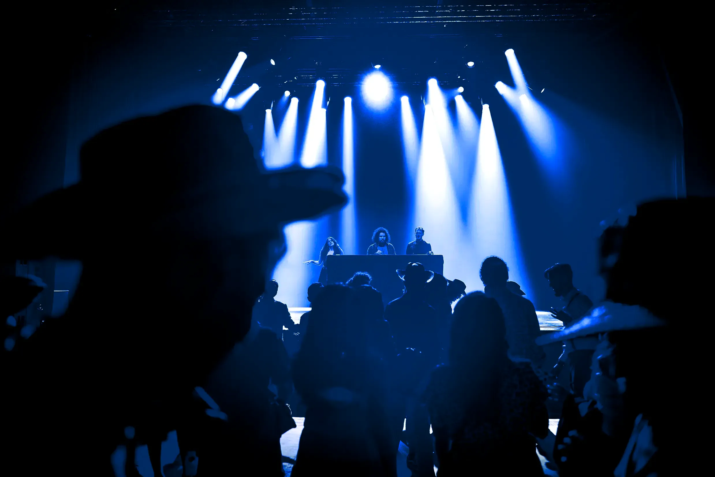 DJ set et public en silhouette sous lumières bleues lors du gala UGA à La Belle Électrique à Grenoble