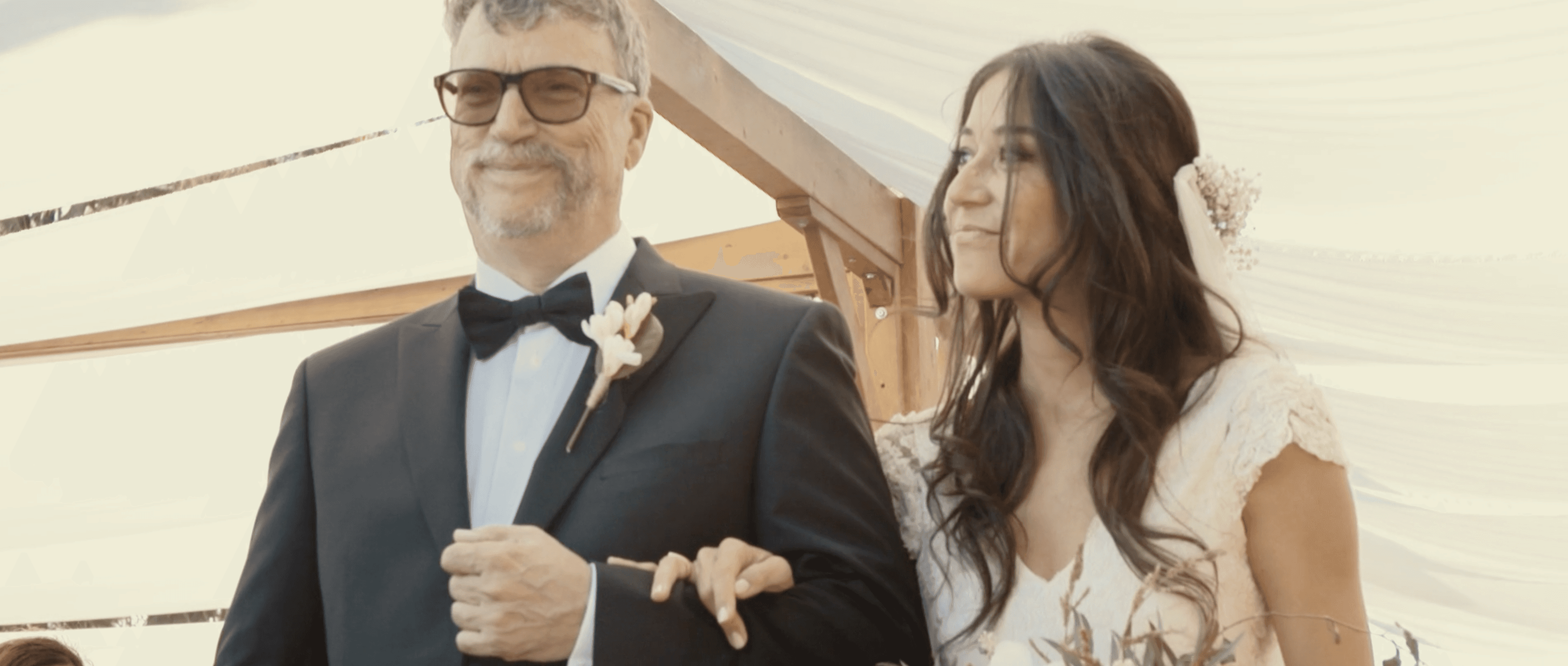 “Bride walking down the aisle with her father during an outdoor wedding ceremony. Emotional moment captured at a destination wedding.”