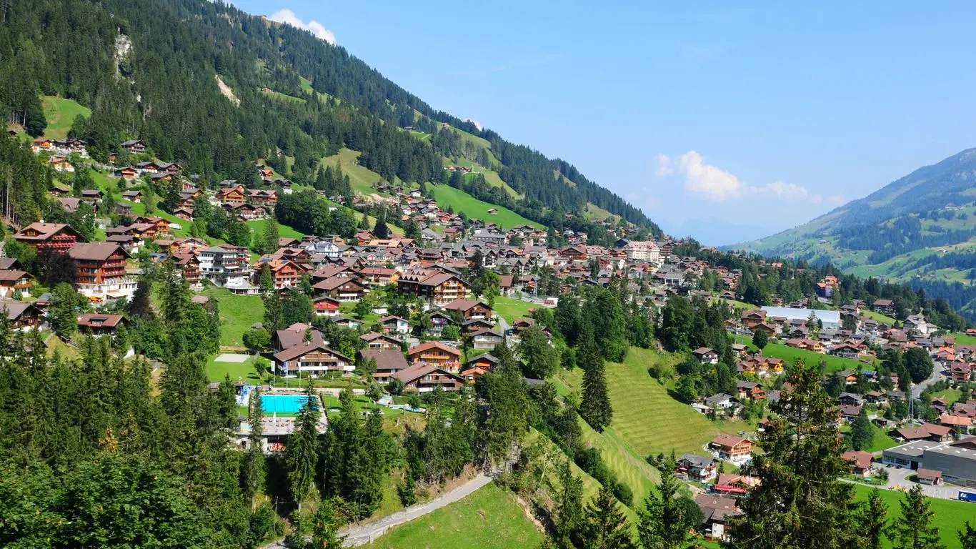 Drohnenaufnahme von Adelboden im Berner Oberland mit Wohnhäusern in alpiner Lage