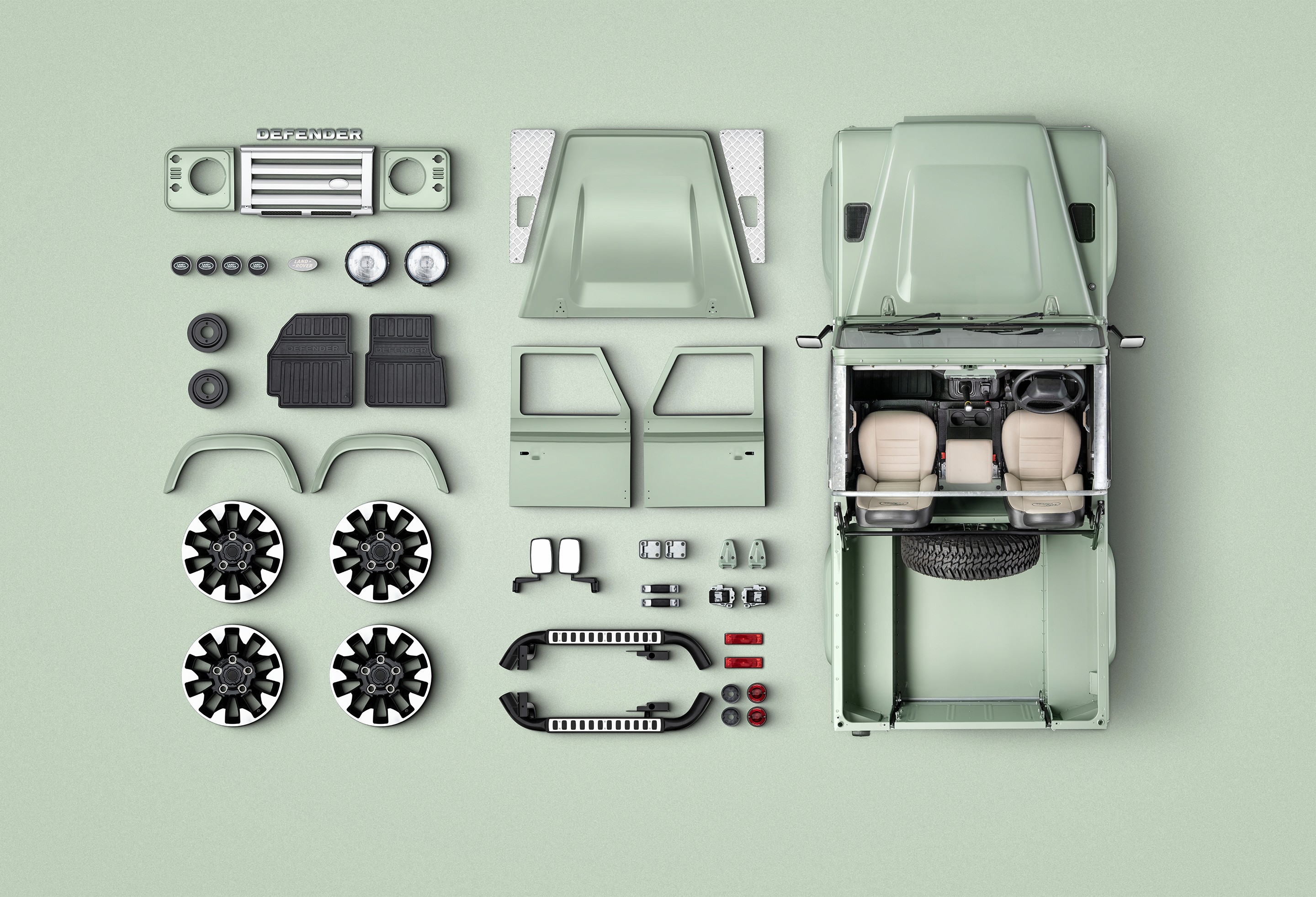 Vehicle body panels and parts arranged in a flat lay on a pale background