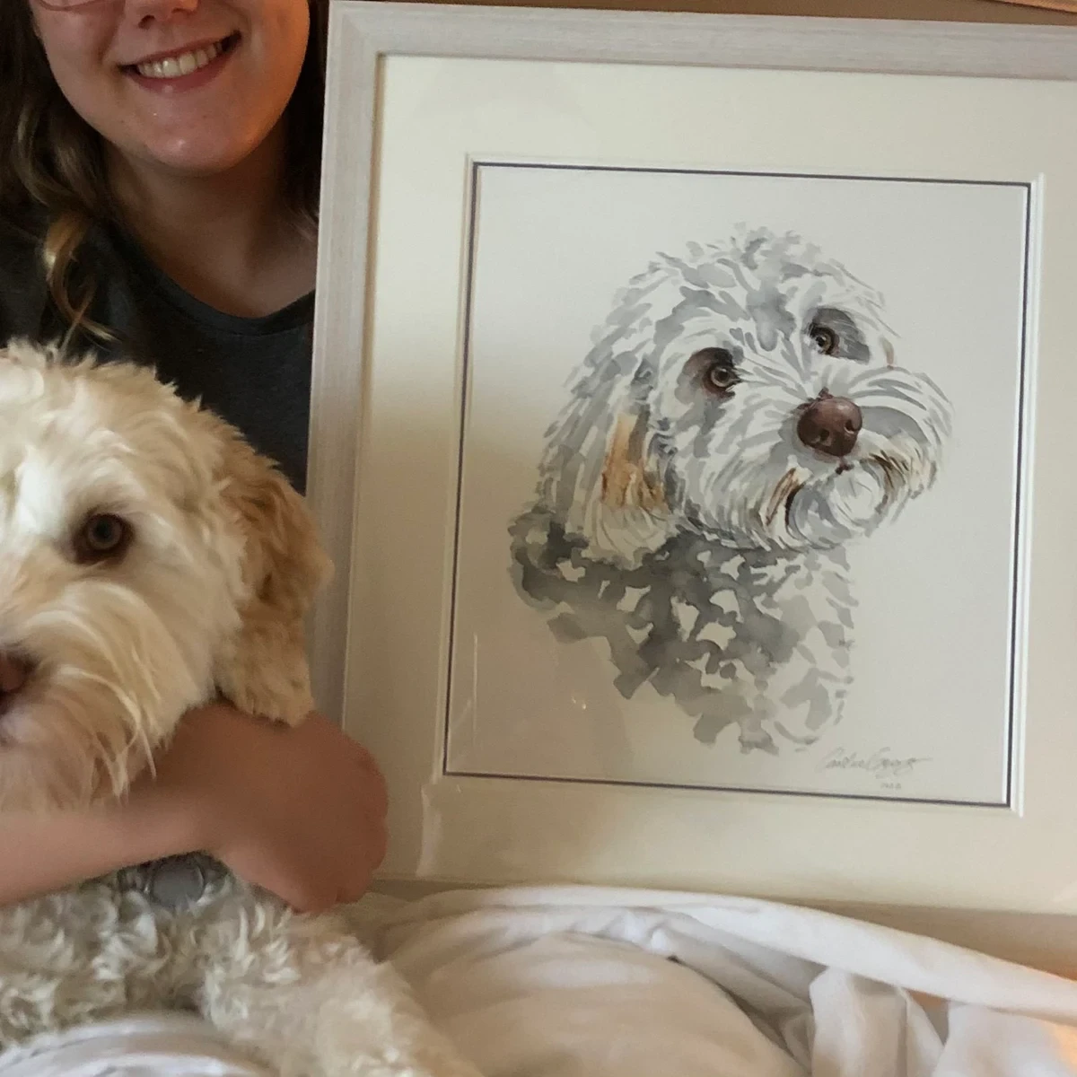 Picture of dog sat next to a painting of itself