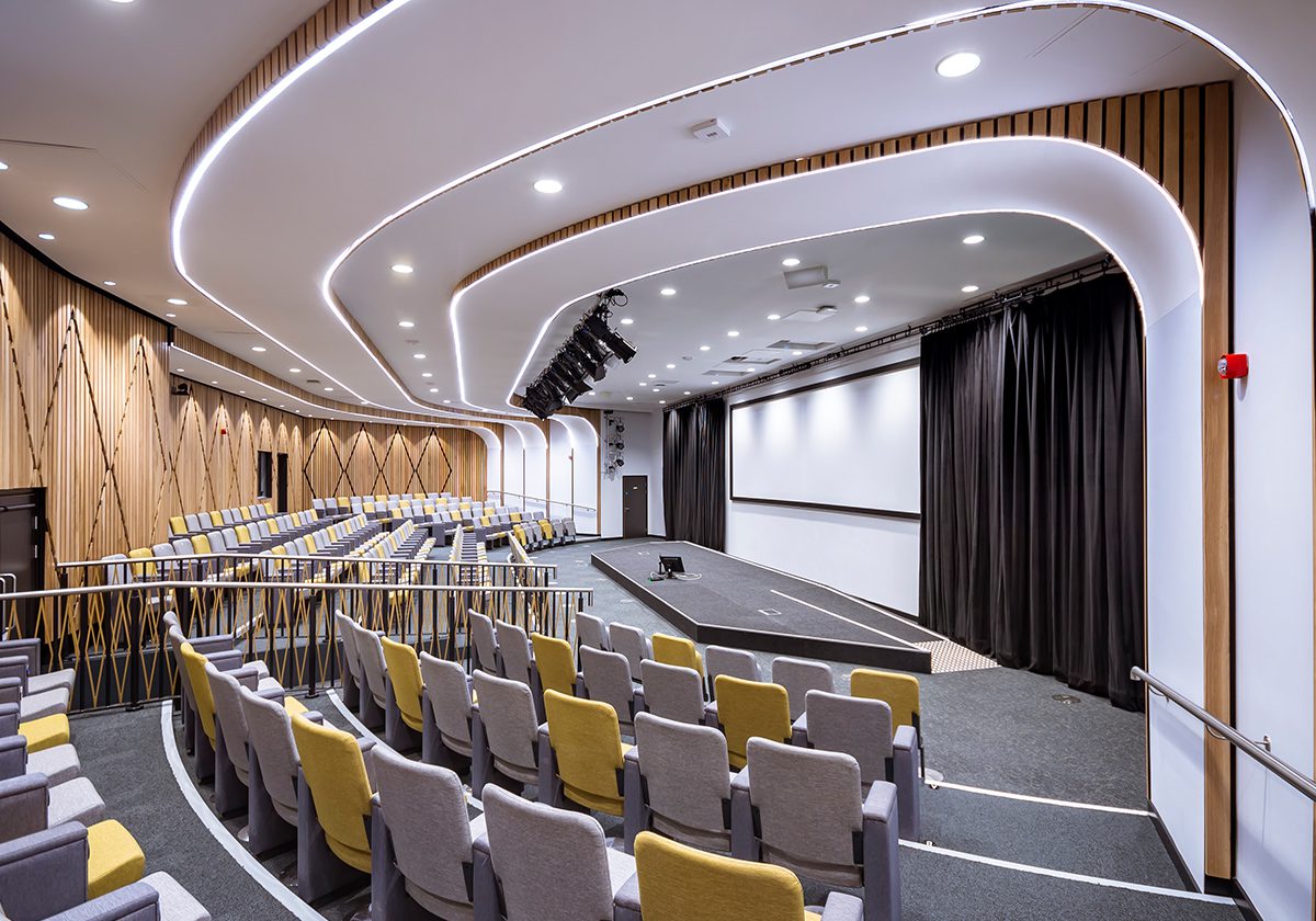 An image of The Theatre in The Catalyst based in Newcastle upon Tyne. The image is taken at the far back right of the room, where backs of chairs can be seen, where they all face the stage. 