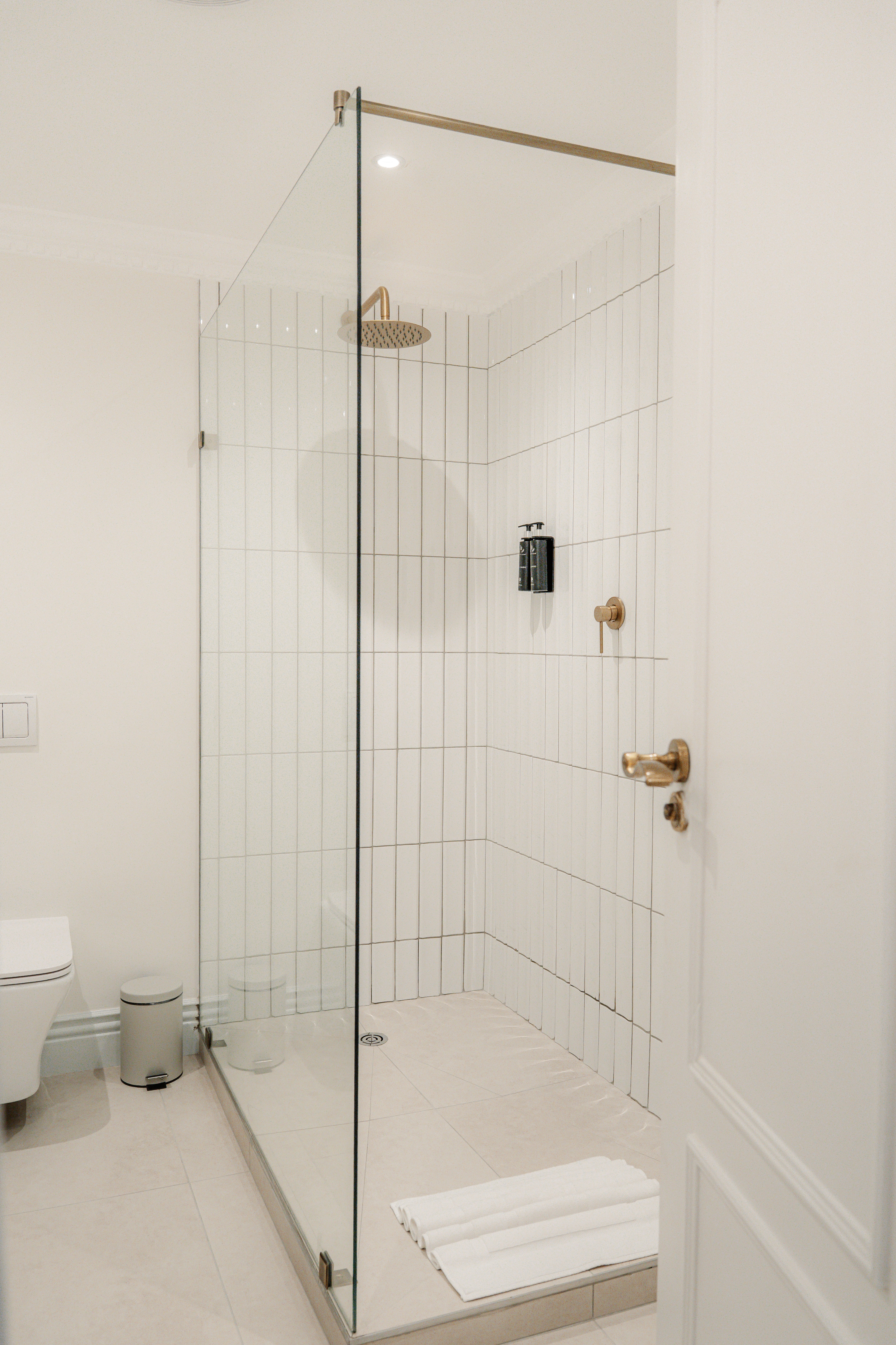 Spacious en-suite shower in Redlands Hotel room with fresh towels.