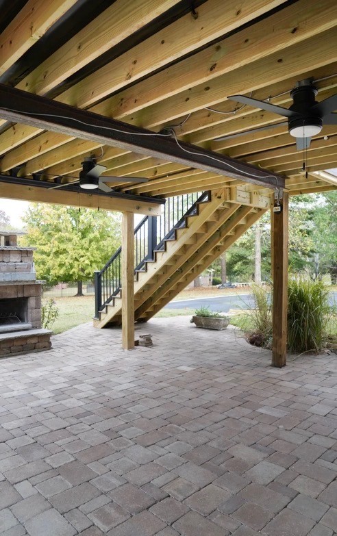 Spacious, luxurious living room with high ceilings, an elegant beige sectional sofa, warm ambient lighting, classical artwork, and rustic architectural elements, featuring an open layout with a view of a mezzanine level.