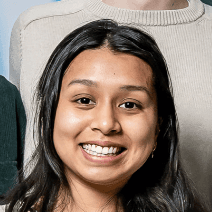 A smiling young woman with dark hair and a warm expression, embodying the vibrant team behind our digital product solutions.