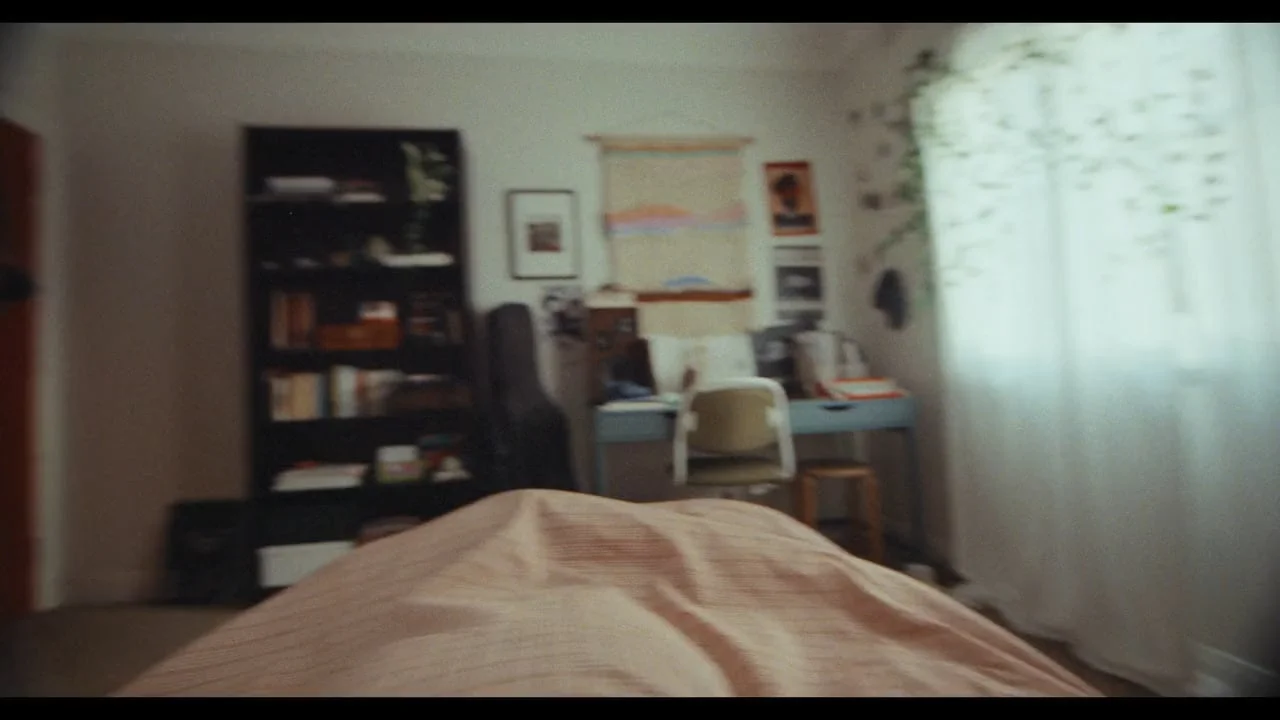 Still from the Only Music film for the Australian Institute of Music: a blurred bedroom with bookshelf, desk and guitar case