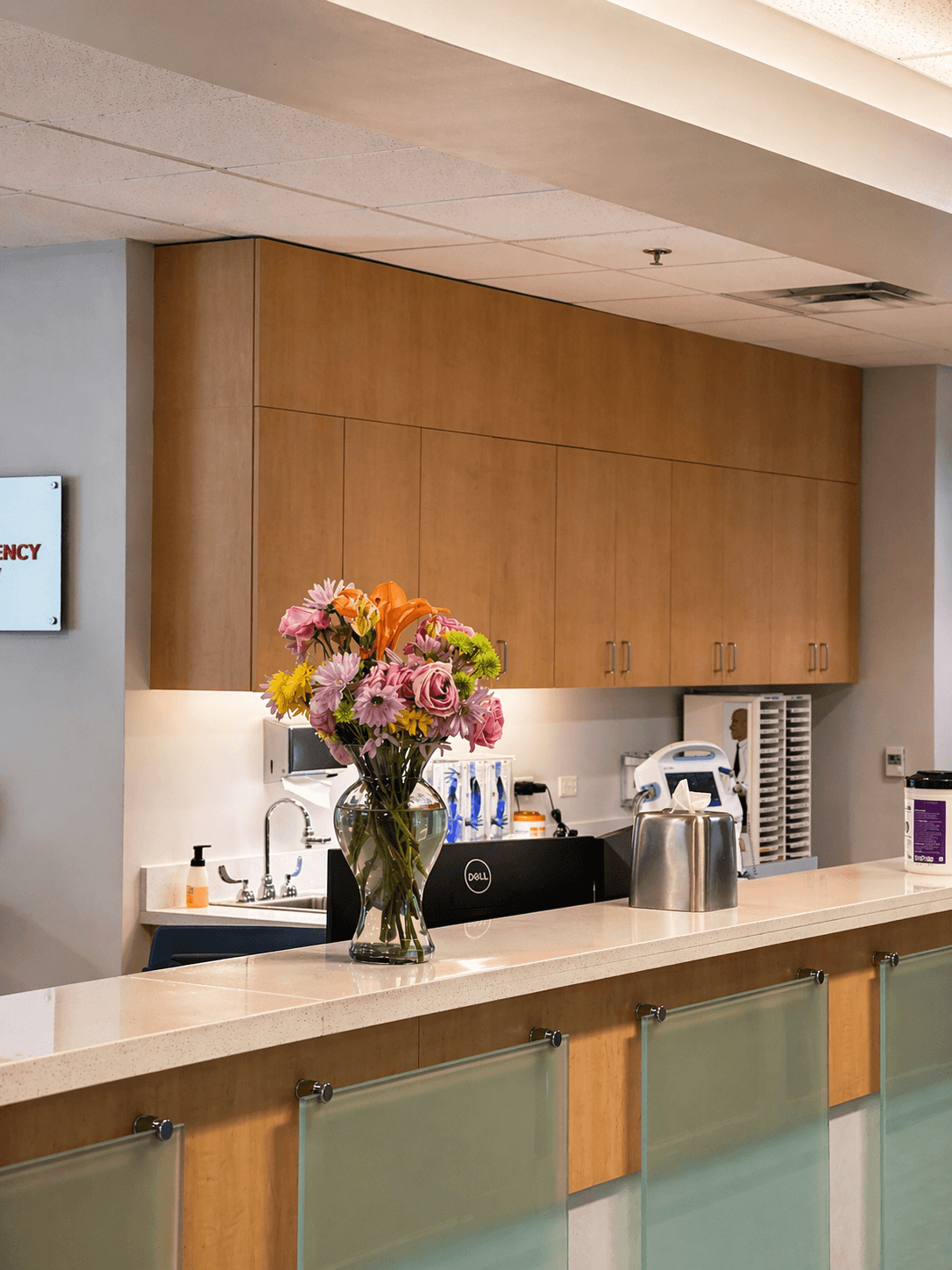 Custom walnut upper cabinets and reception counter in medical office interior by QW Kitchen & Bath Austin Texas