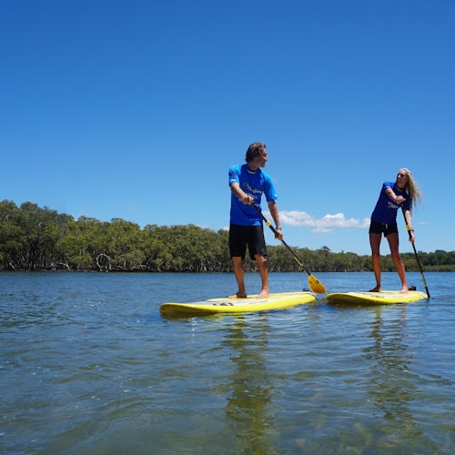 Isang guro ang gumagabay sa isang paddleboarder pababa ng ilog