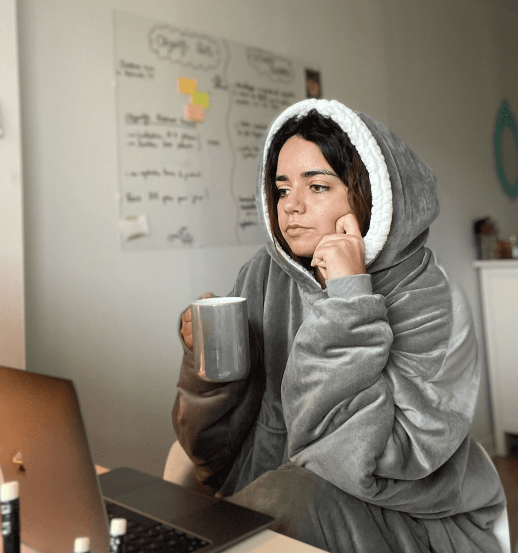 Photo de Sarah Oirdighi de l'agence l'agence de personal branding COLORS en train de travailler sur son laptop.