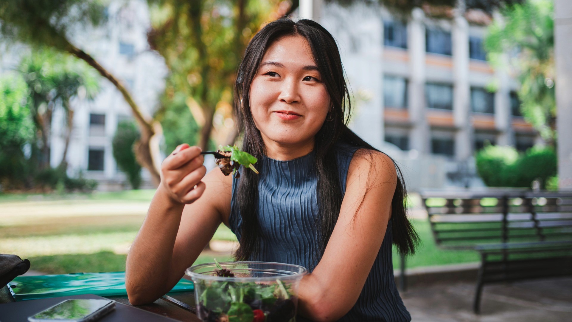 Young Women Sitting and Eating outside of her office
