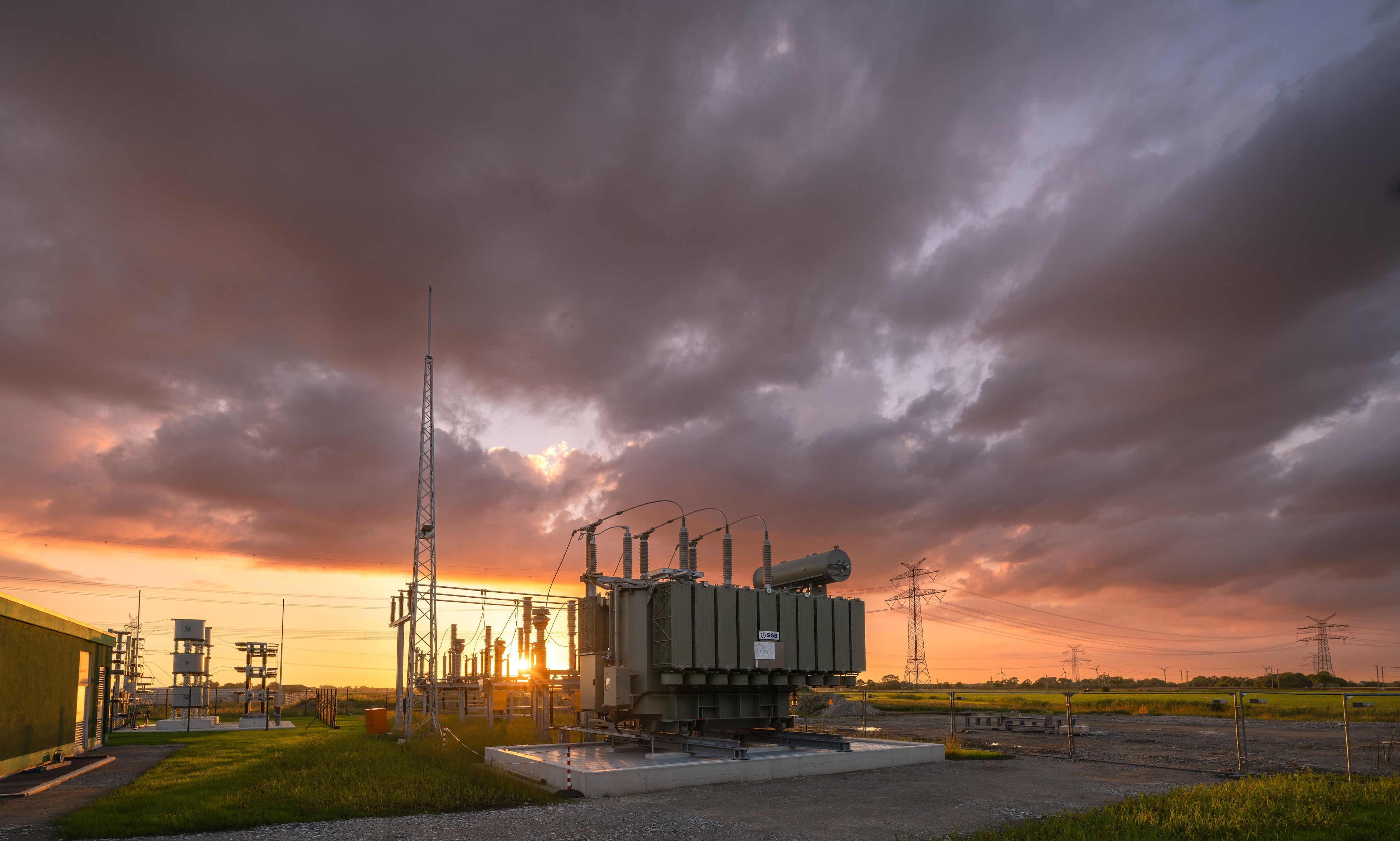 Bilck auf das Umspannwerk im Hybriden Energiepark Sande bei Sonnenuntergang