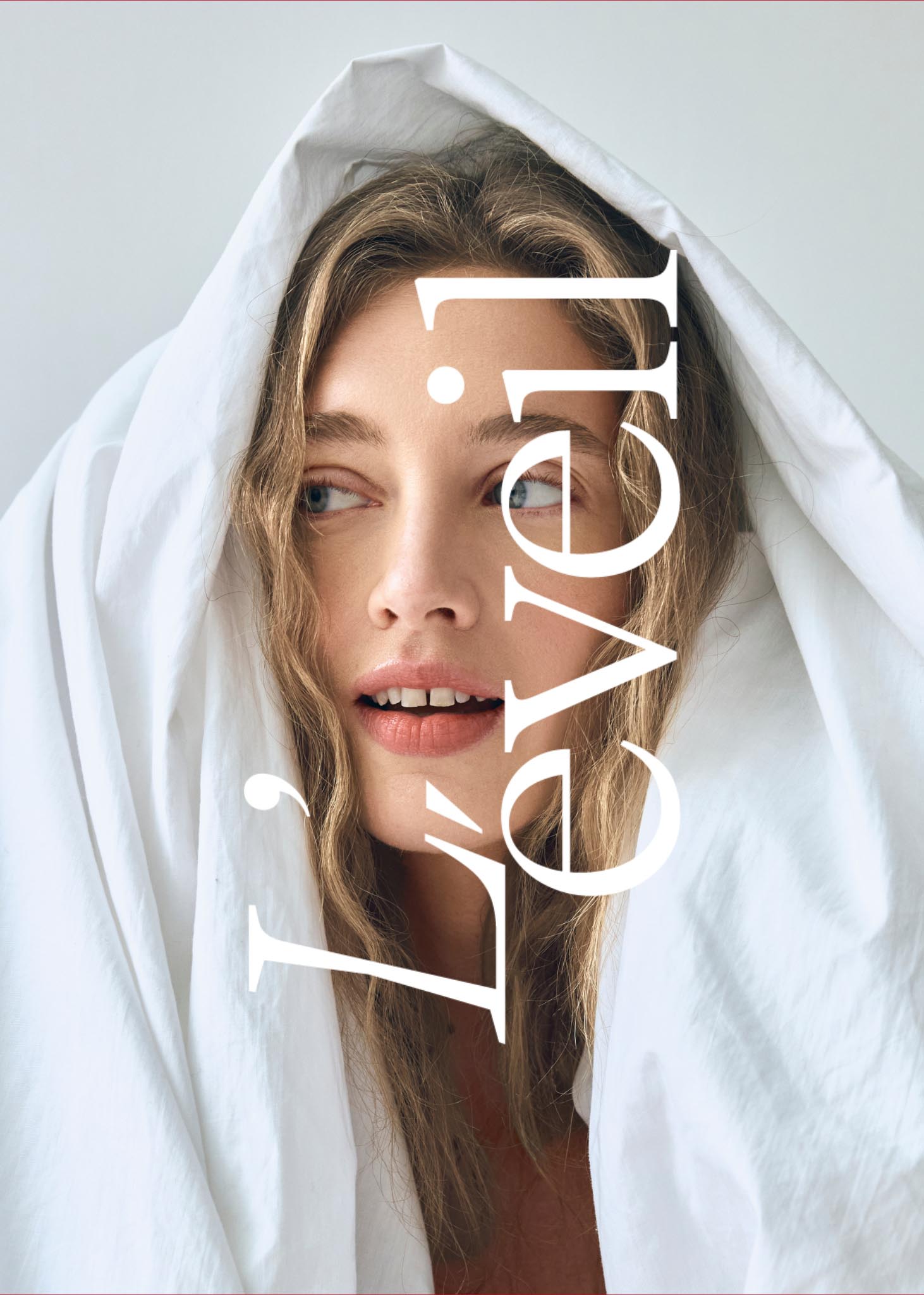 Portrait d’une femme entourée d’un drap blanc, regardant sur le côté, en lumière naturelle