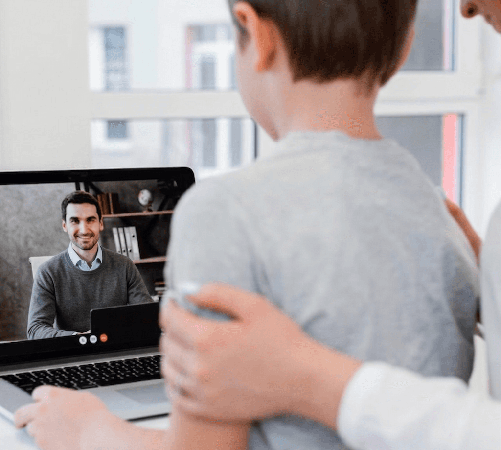 A man in a white lab coat working at a computer, viewing a 3D model on the screen in a laboratory or office setting.