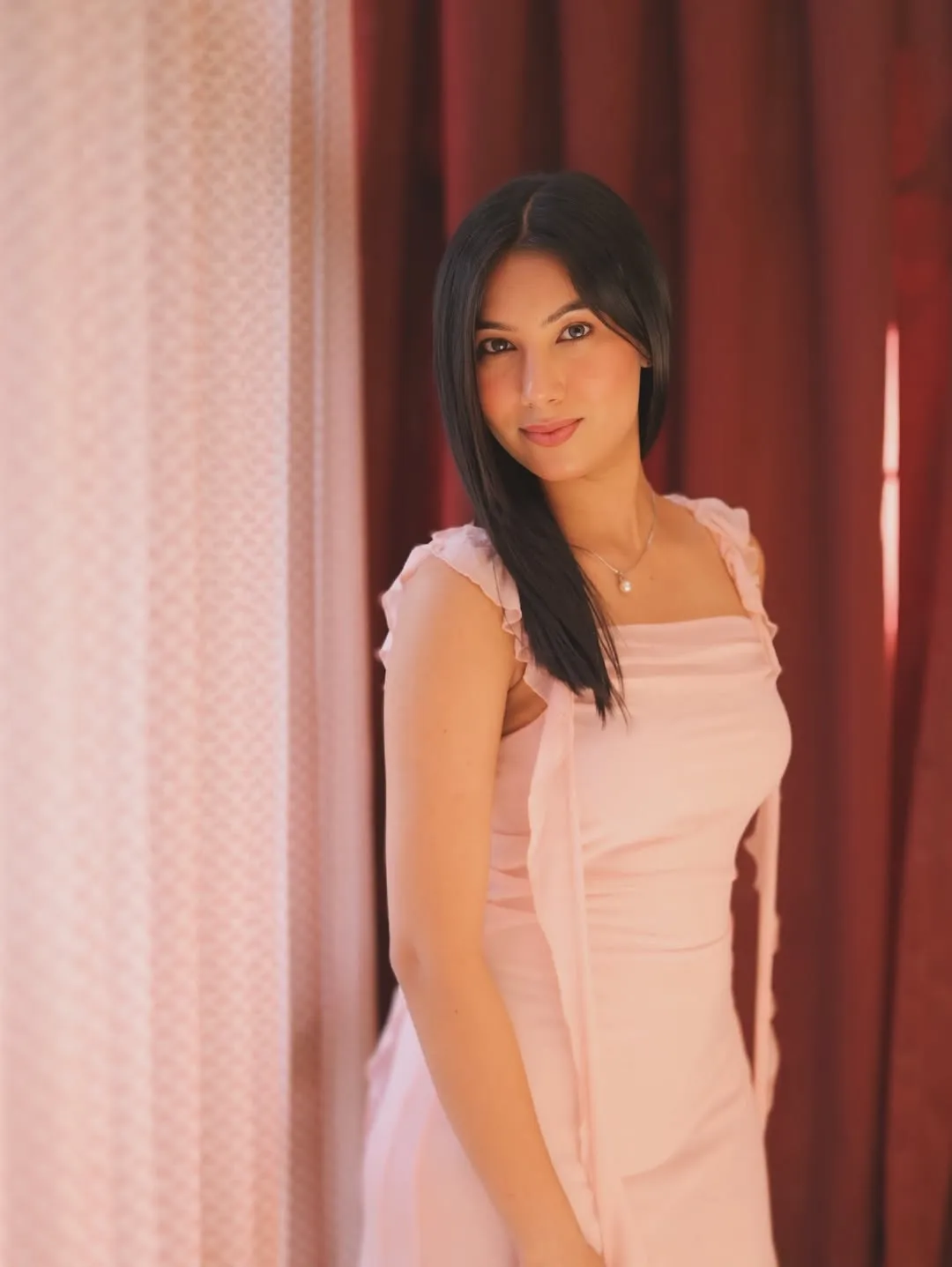 woman looking sideways leaning on white wall