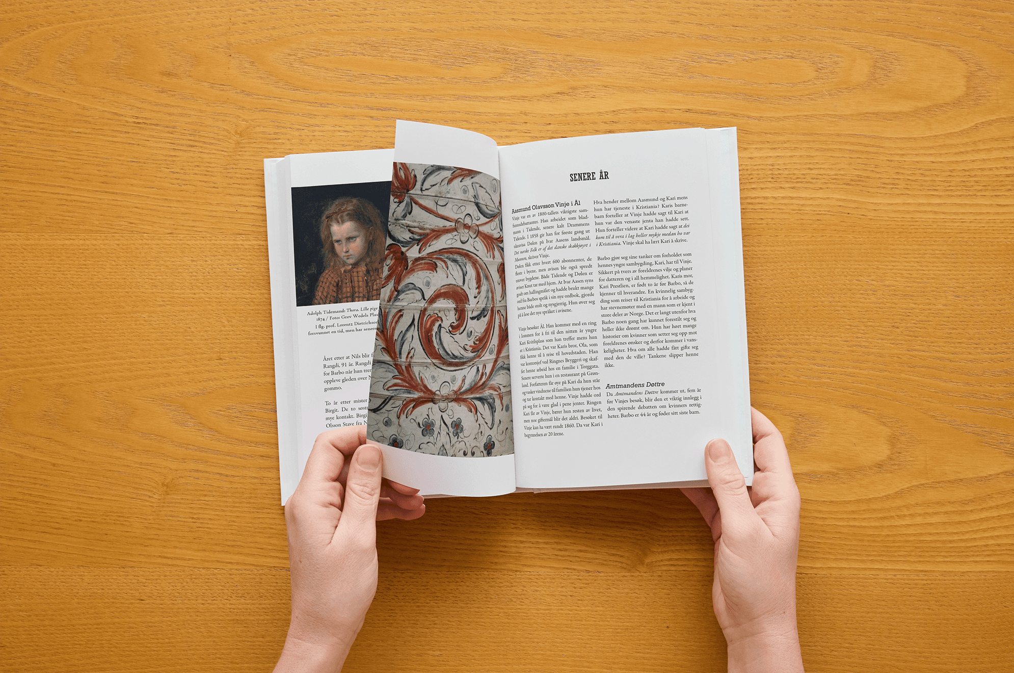 Ręce trzymają książkę podczas przewracania strony z obrazem i portretem.