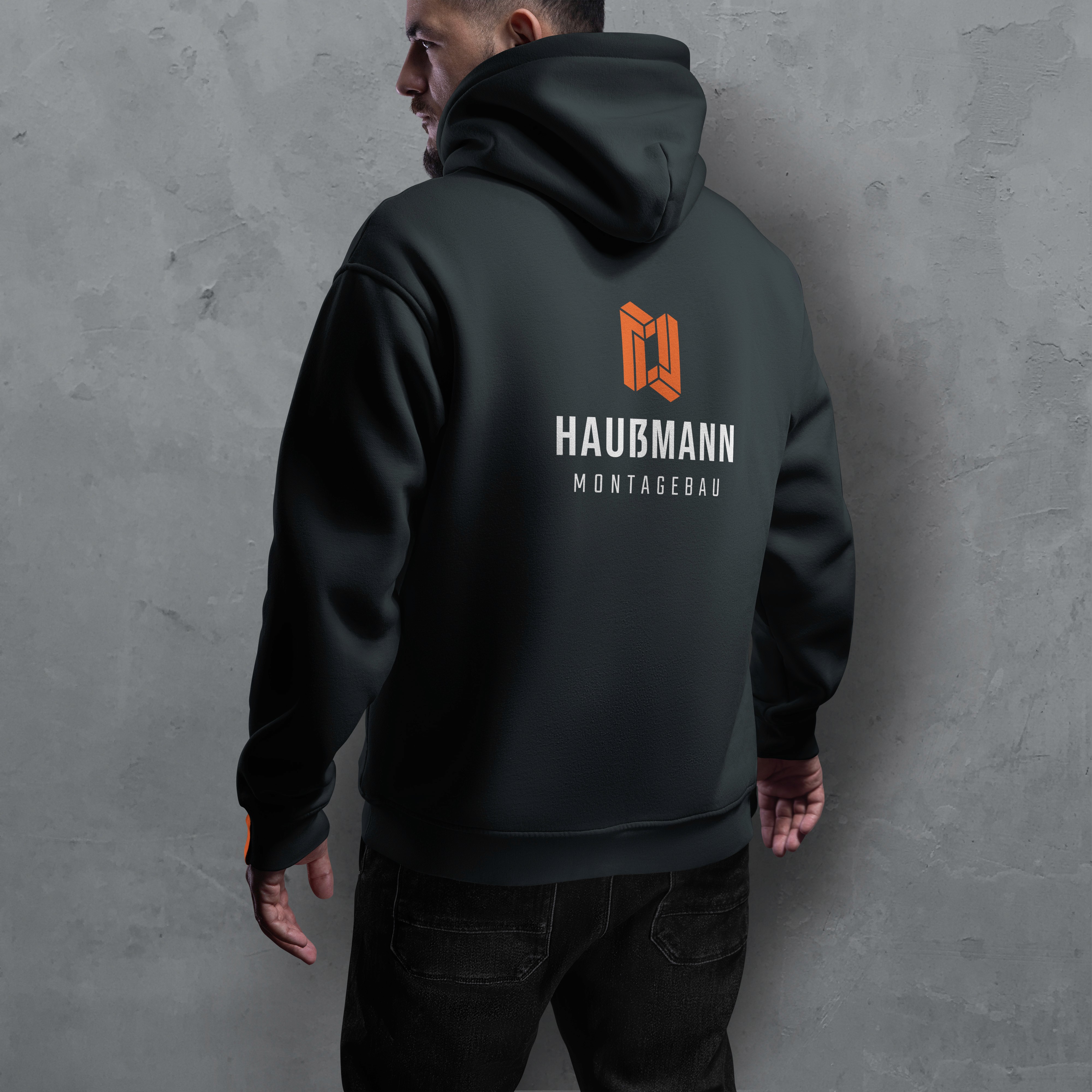 Schwarzer Pullover mit Haussmann Montagebau-Logo auf dem Rücken, schlichtes und modernes Design für Firmenbranding.