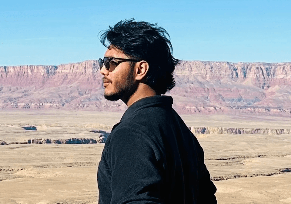 Stylized blue-toned illustration of a bearded man in profile wearing glasses and a collared shirt.