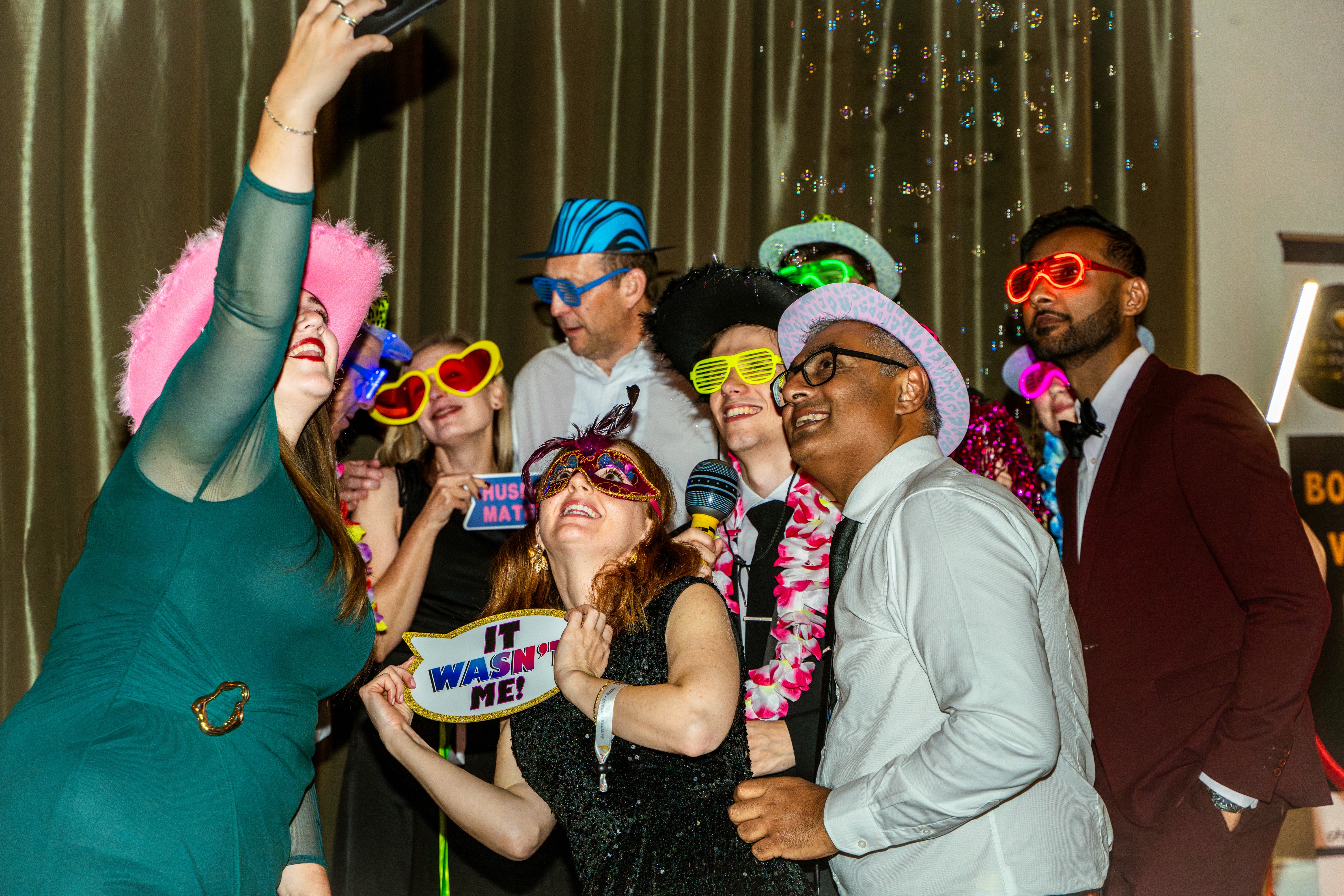 Group of people in photobooth dress up at black tie event