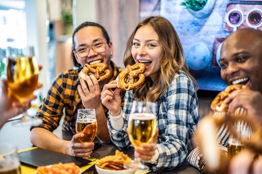 Group of friends at a table raising glasses and laughing