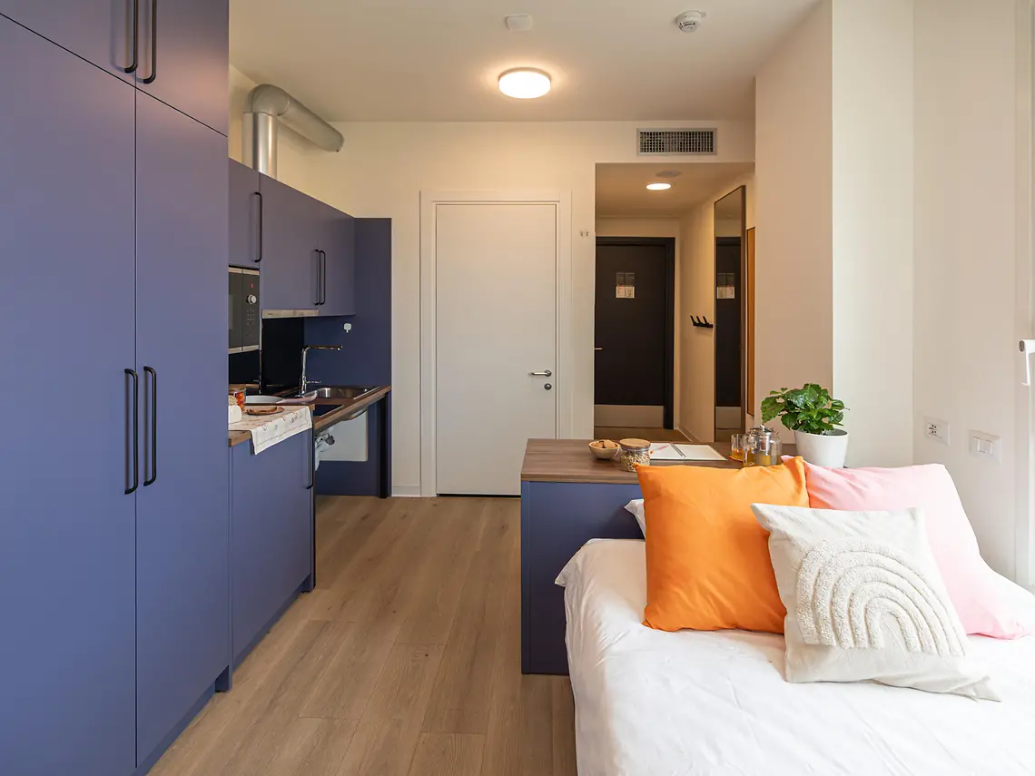 Open-plan student studio in Bologna with fitted kitchen, bed and breakfast bar