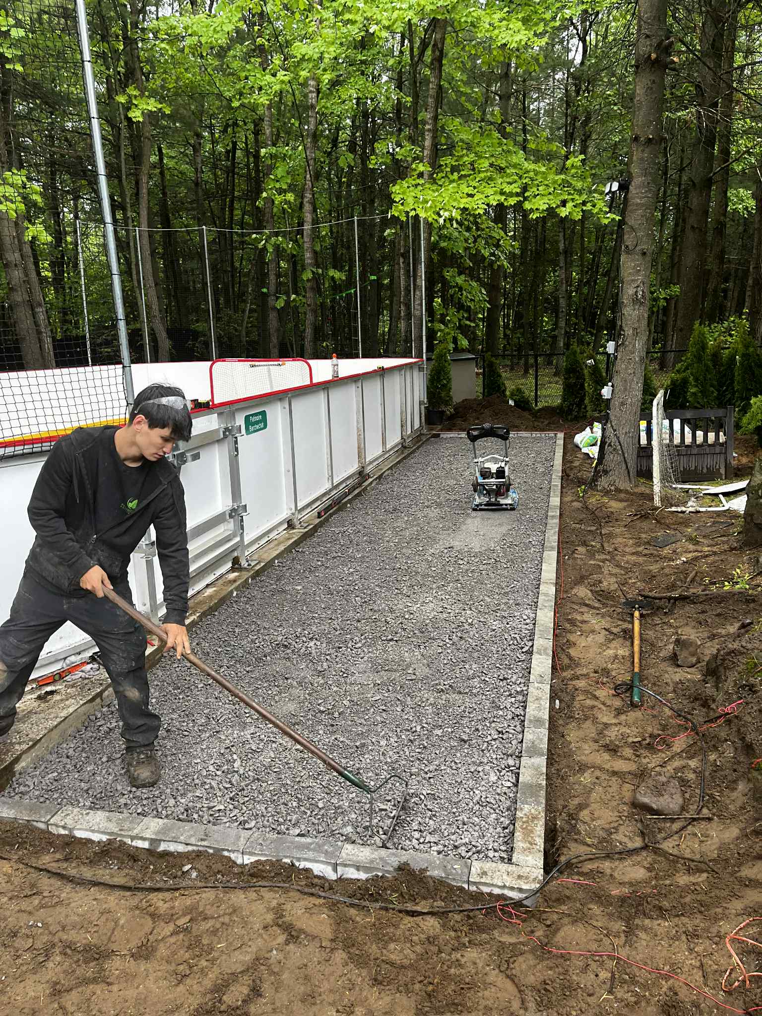 Aménagement de cour arrière avec plates-bandes et pavés réalisé par Pelouse Men Paysagement.