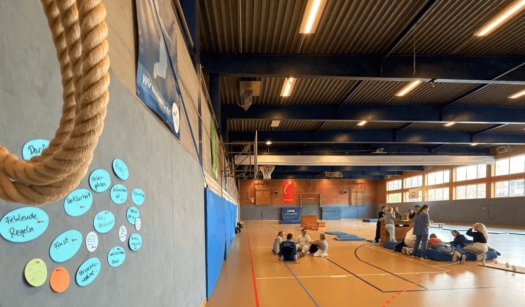 Teamentwicklung in der Turnhalle. Zwei Teams entwickeln bessere Zusammenarbeit