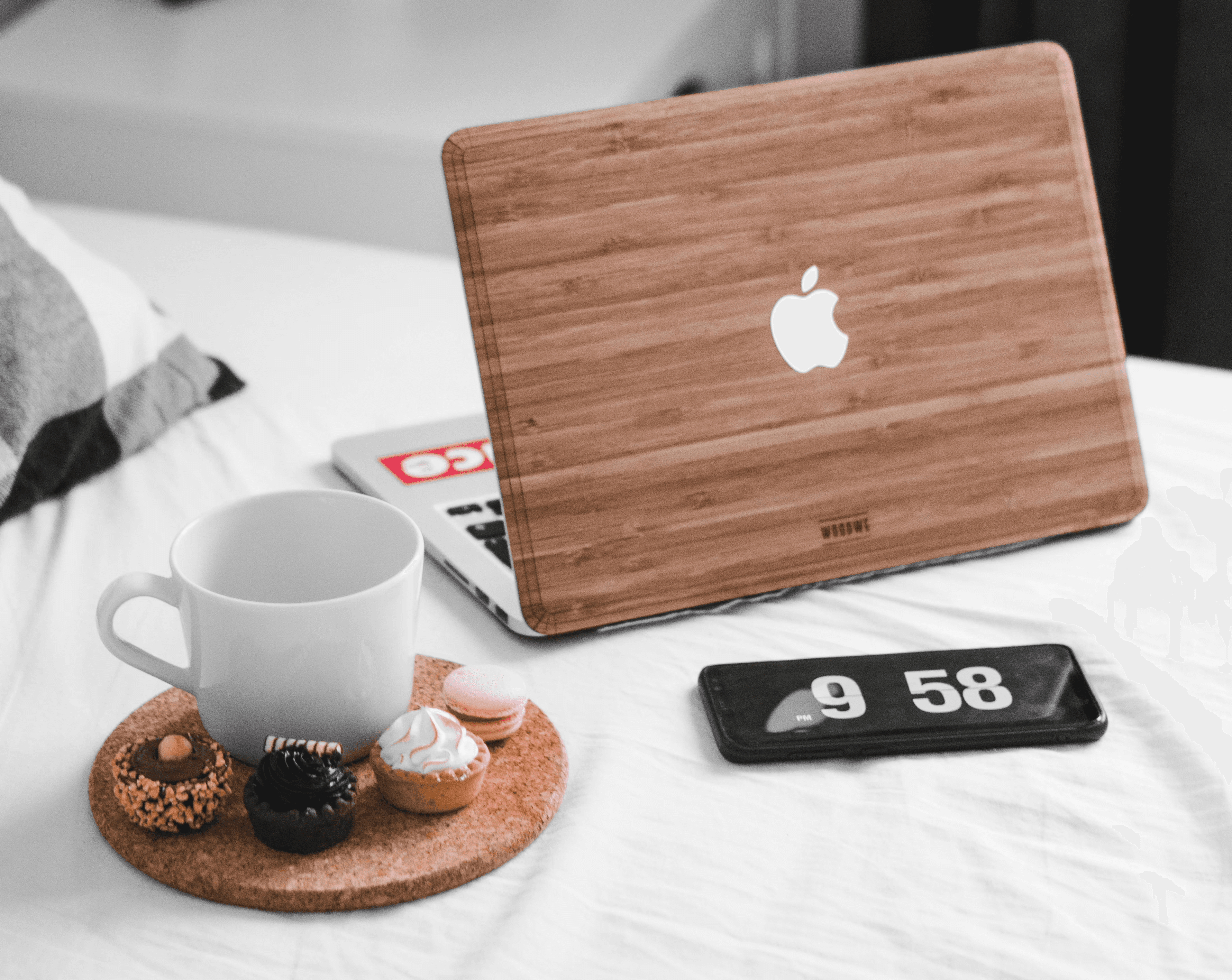MacBook beside white mug