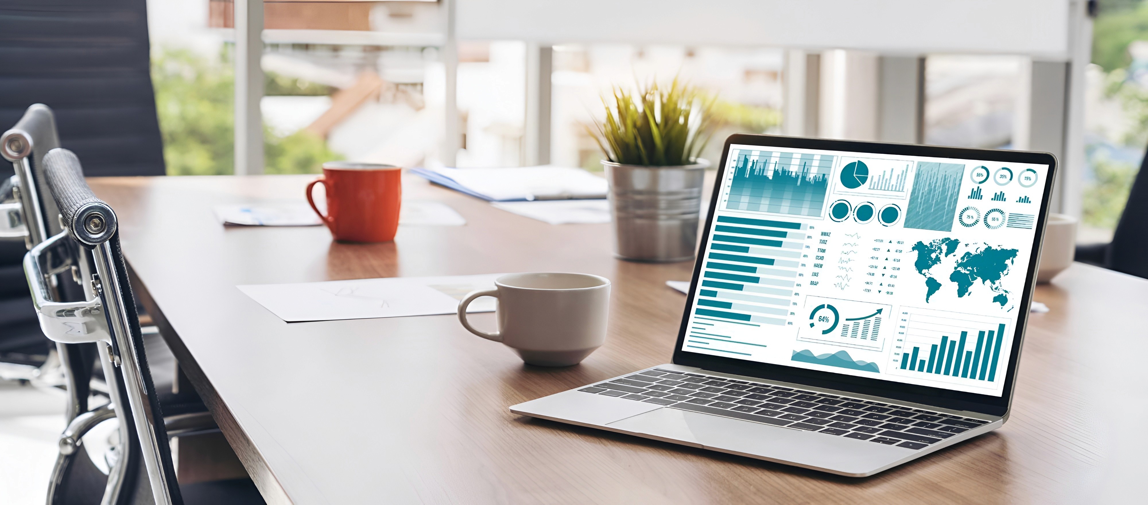 Laptop showing analytics dashboards and business intelligence reports in a modern meeting room.