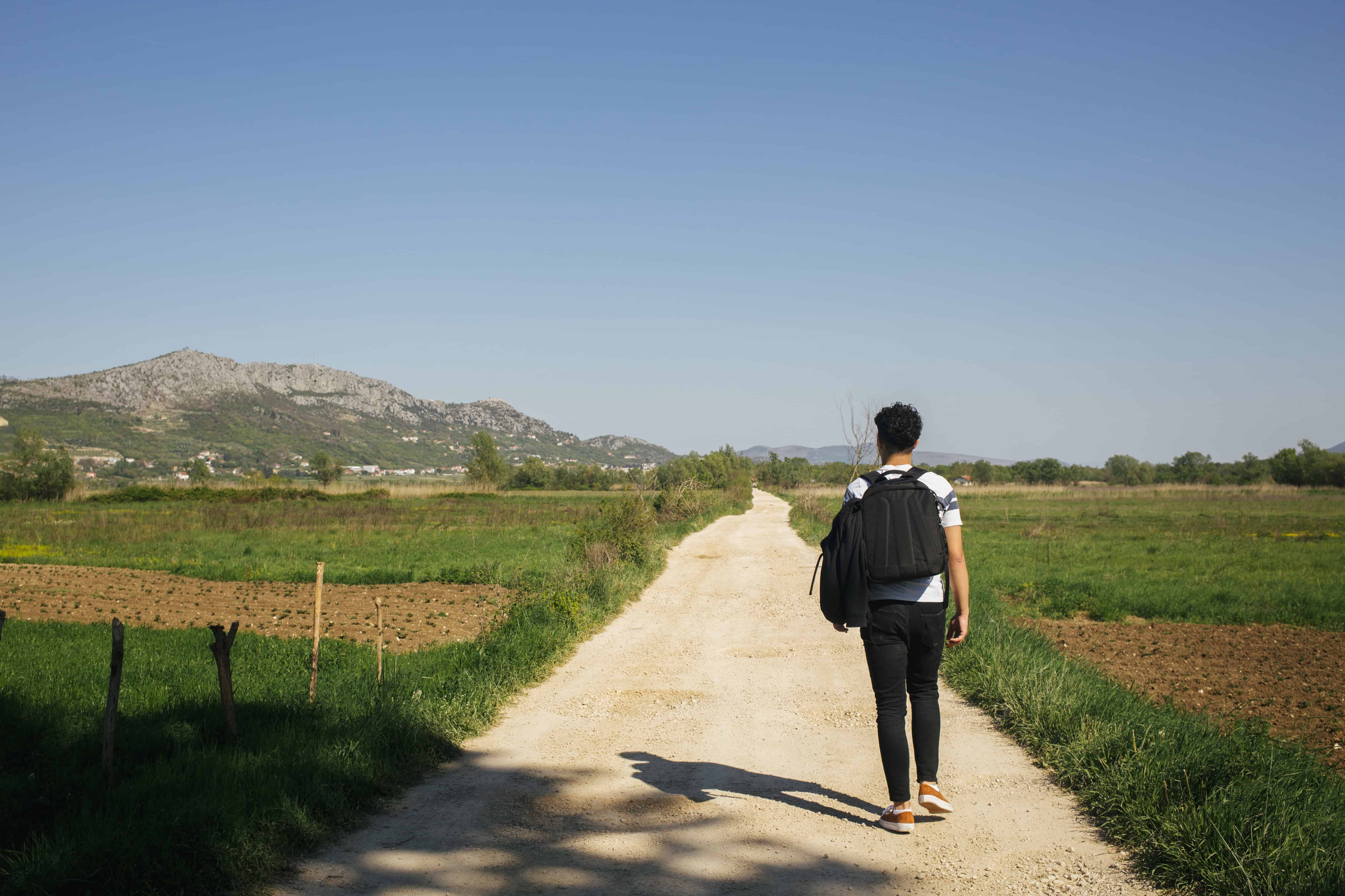 Évolution personnelle en pleine nature, marche sur un chemin rural ensoleillé.