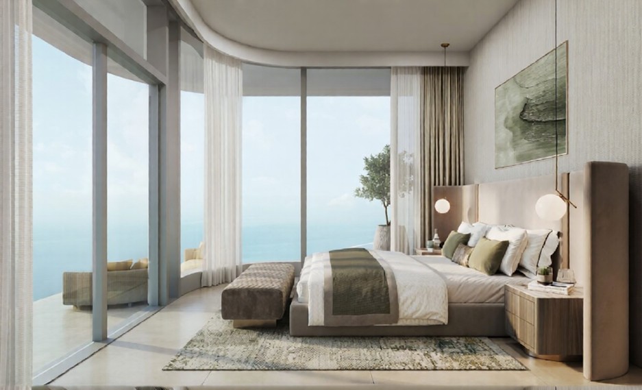 Master bedroom in the Hilton Residences with a curving floor-to-ceiling glass wall offering panoramic ocean views.