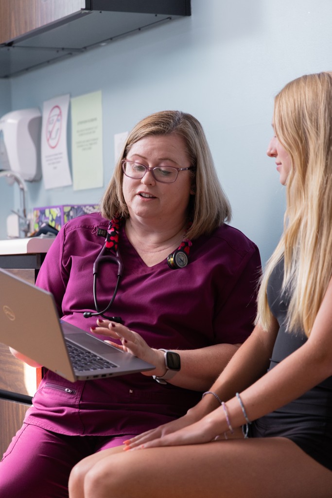 Nurse Practitioner sharing a laptop with a family member.