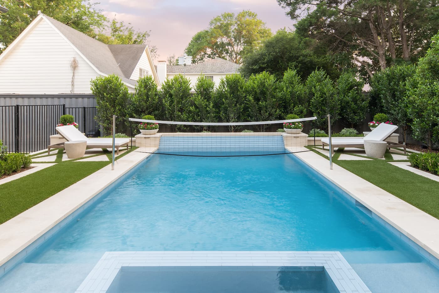 Rectangular swimming pool with geometric spa design and symmetrical lounge areas in North Dallas backyard