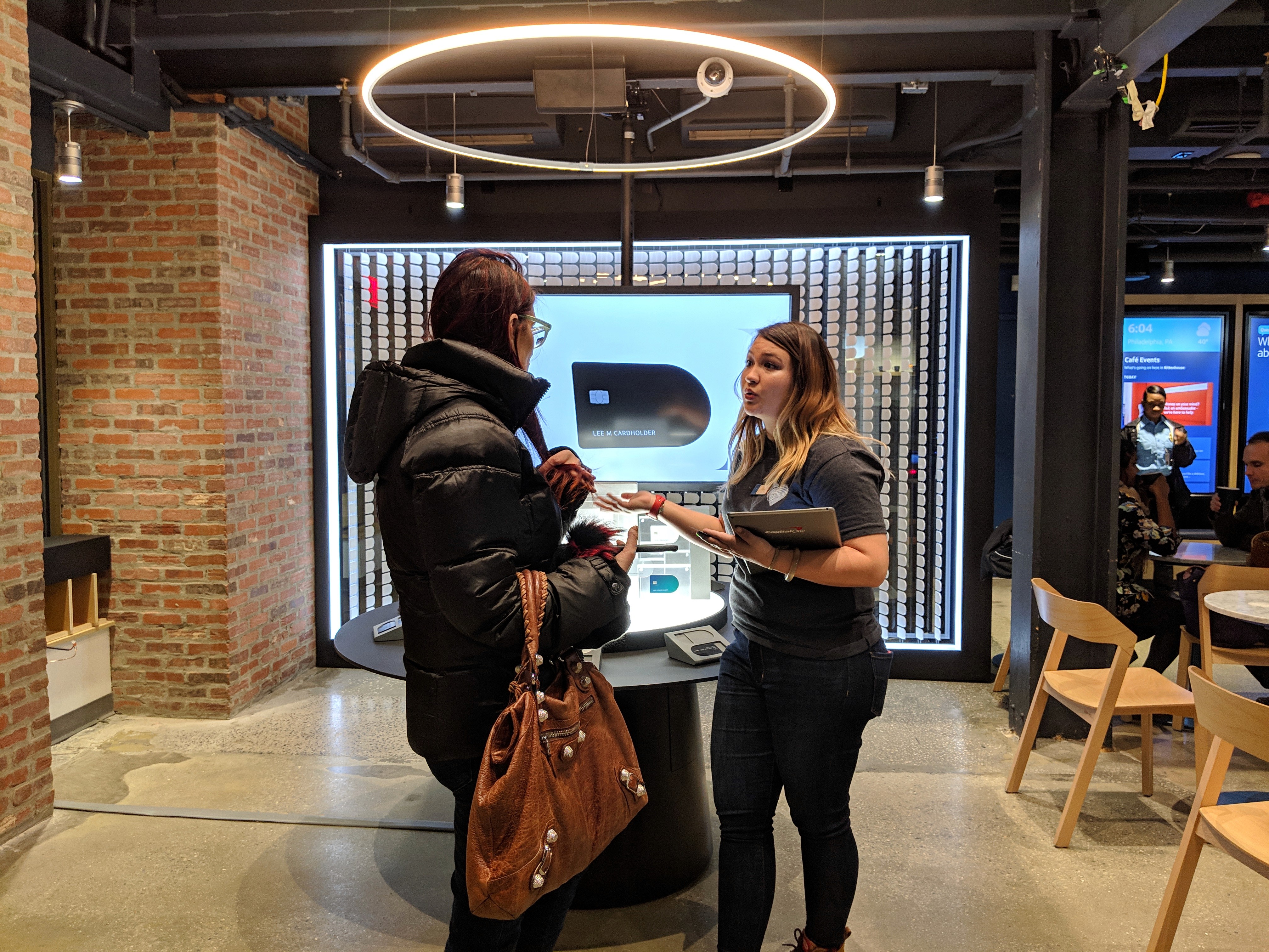 Picture of a capital One ambassador helping a customer sign up for the Elements Card.