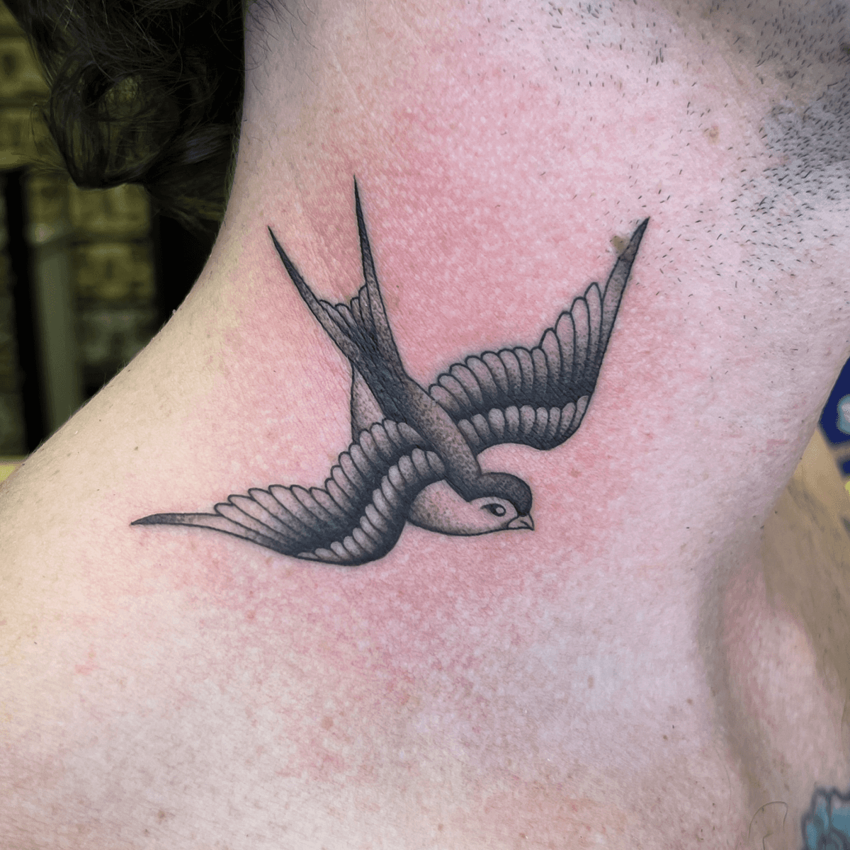 black and gray tattoo of a swallow on a neck