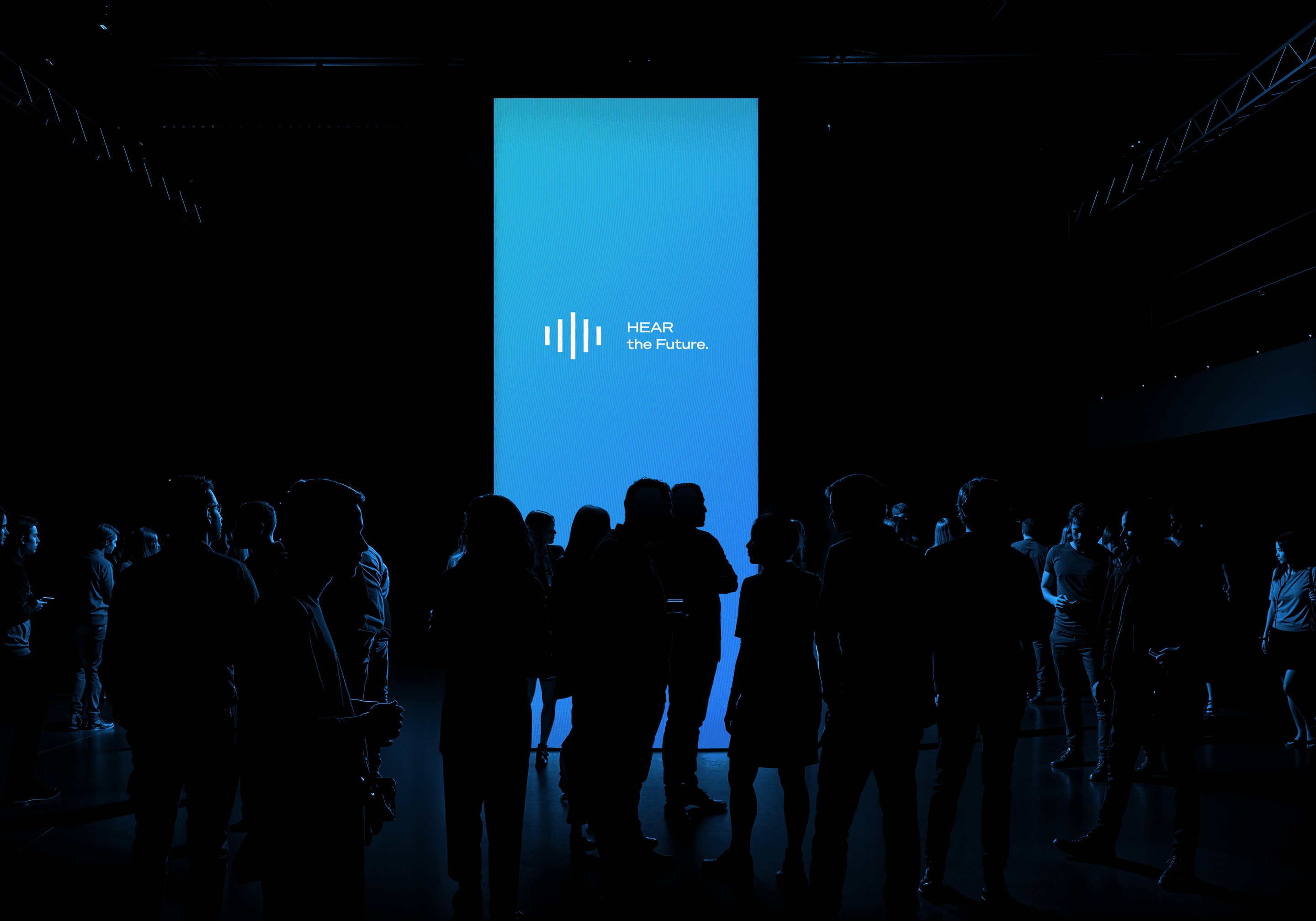 Tall blue vertical LED screen featuring "HEAR the Future" branding at an interactive event exhibition.