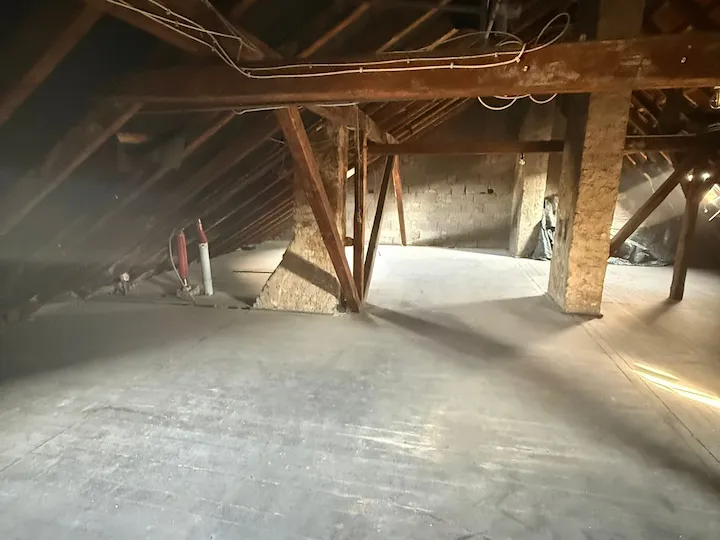 Leergeräumter Dachboden mit Holzbalken nach der Sperrmüllentsorgung