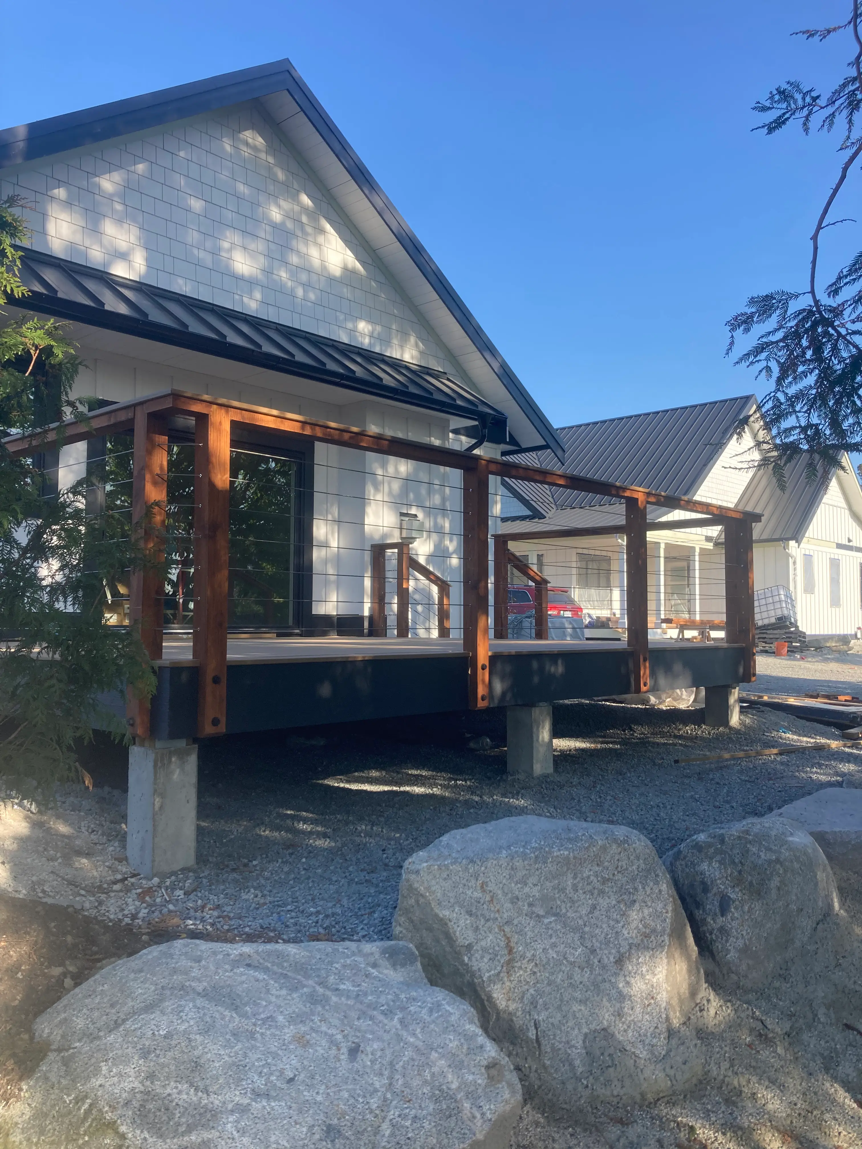 Raised wood deck with cable railing attached to modern home.