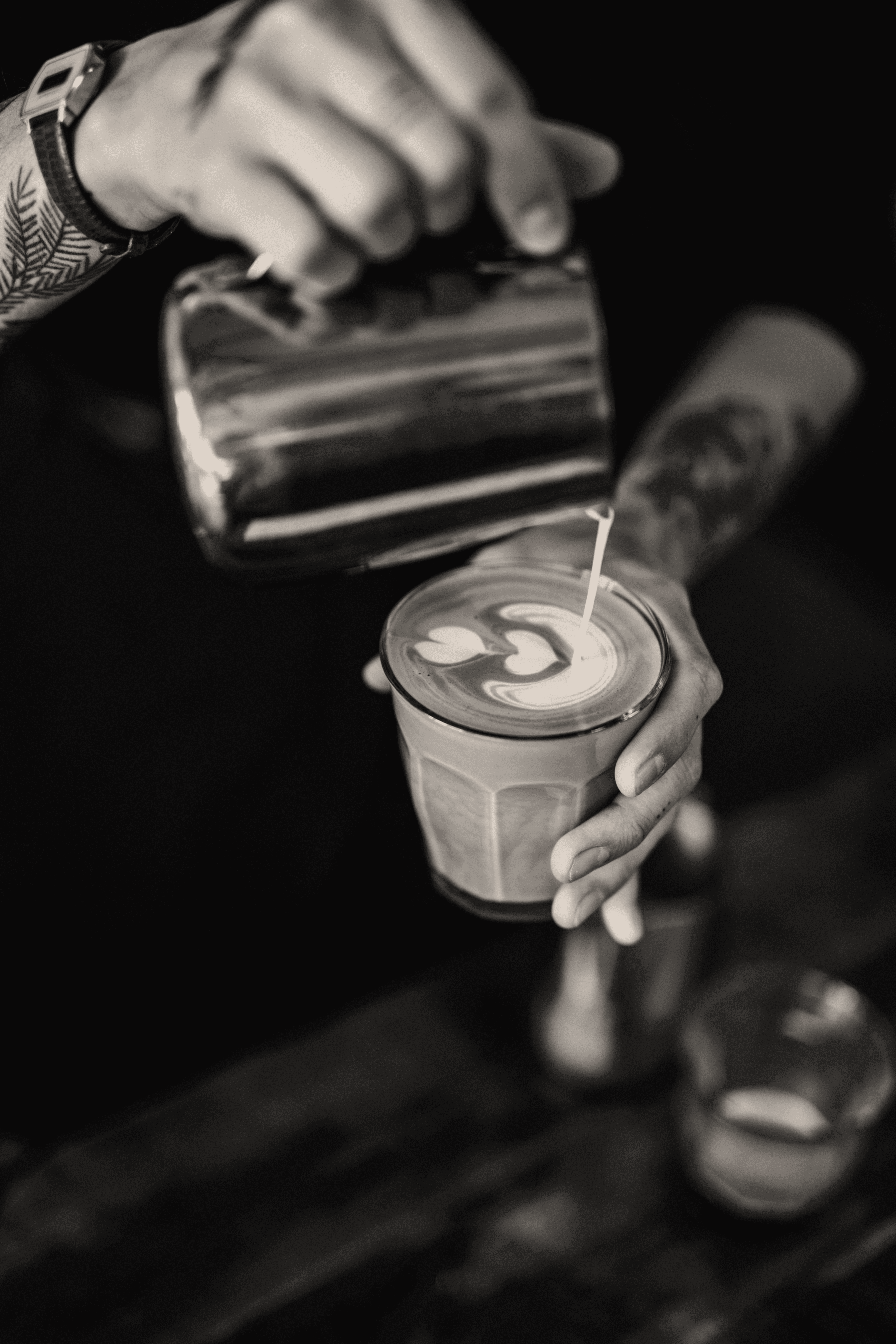 man pouring milk in coffee