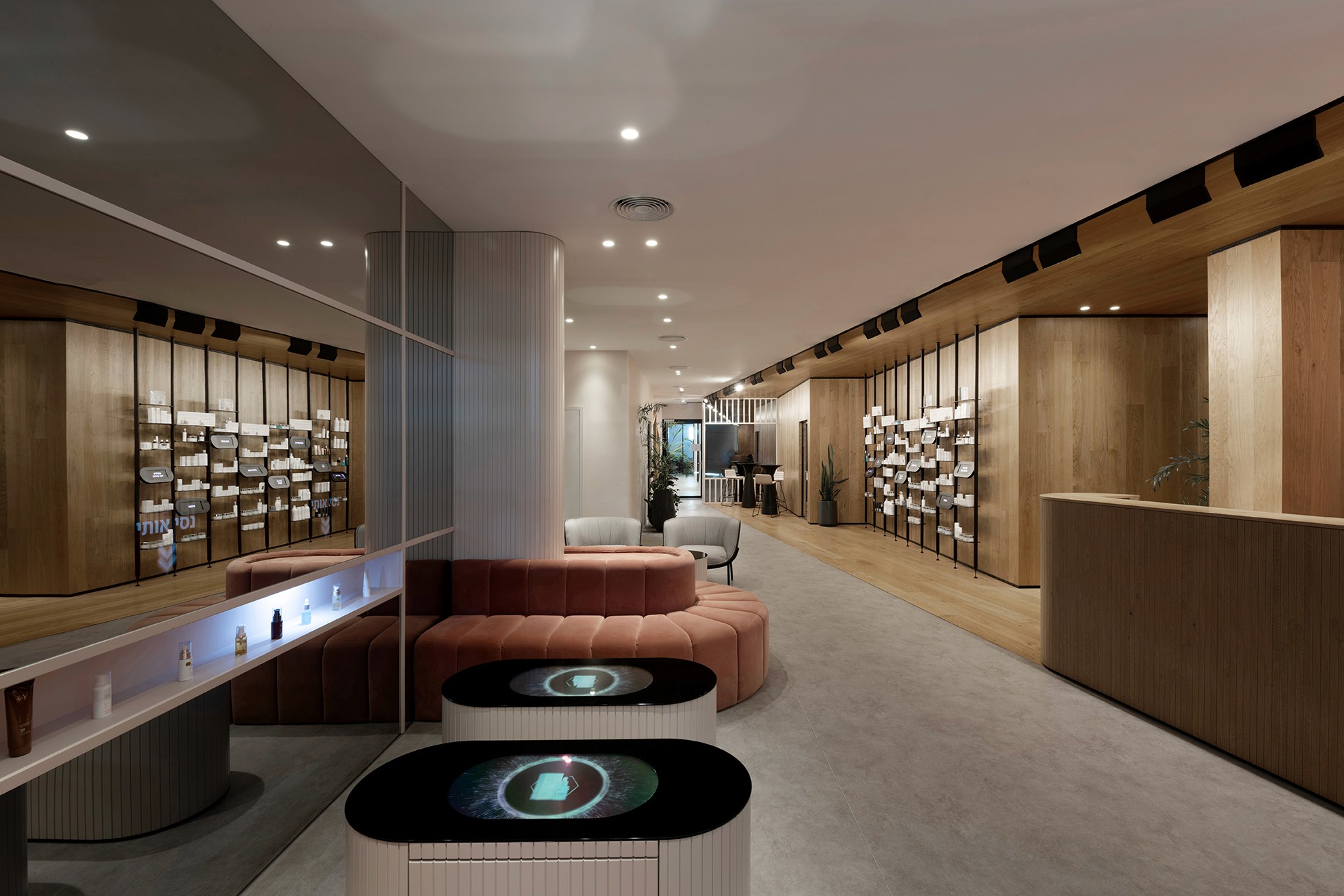 אזור הדיאגנוסטיקה: קיר מראות חכמות (Smart Mirrors) המשלב מסכים נסתרים להצגת מידע, מעל ספסלי ישיבה מרופדים בקטיפה ורודה.