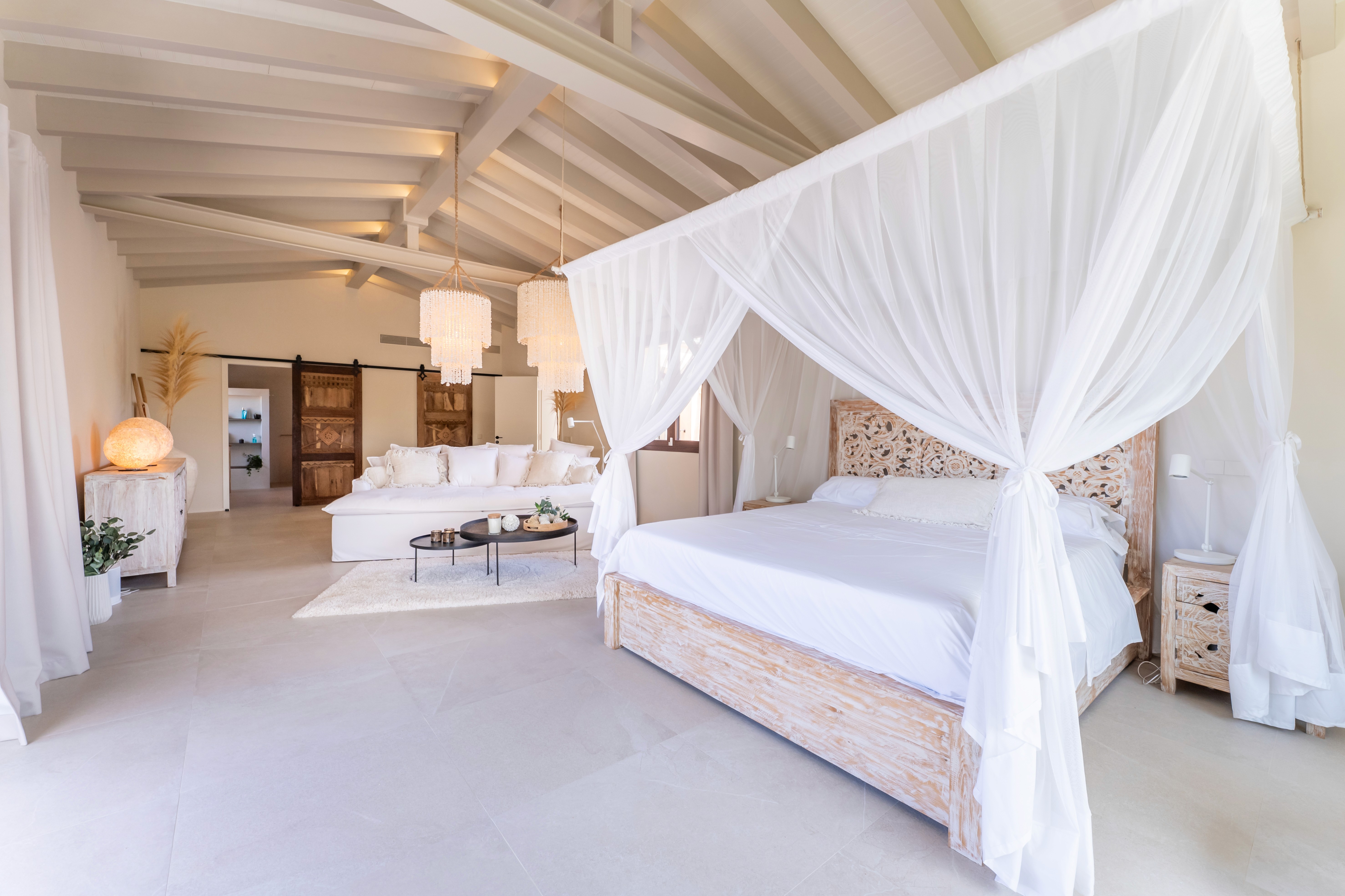 Schlafzimmer der Finca in Llucmajor mit Himmelbett, Leinenstoffen und warmen Naturtönen