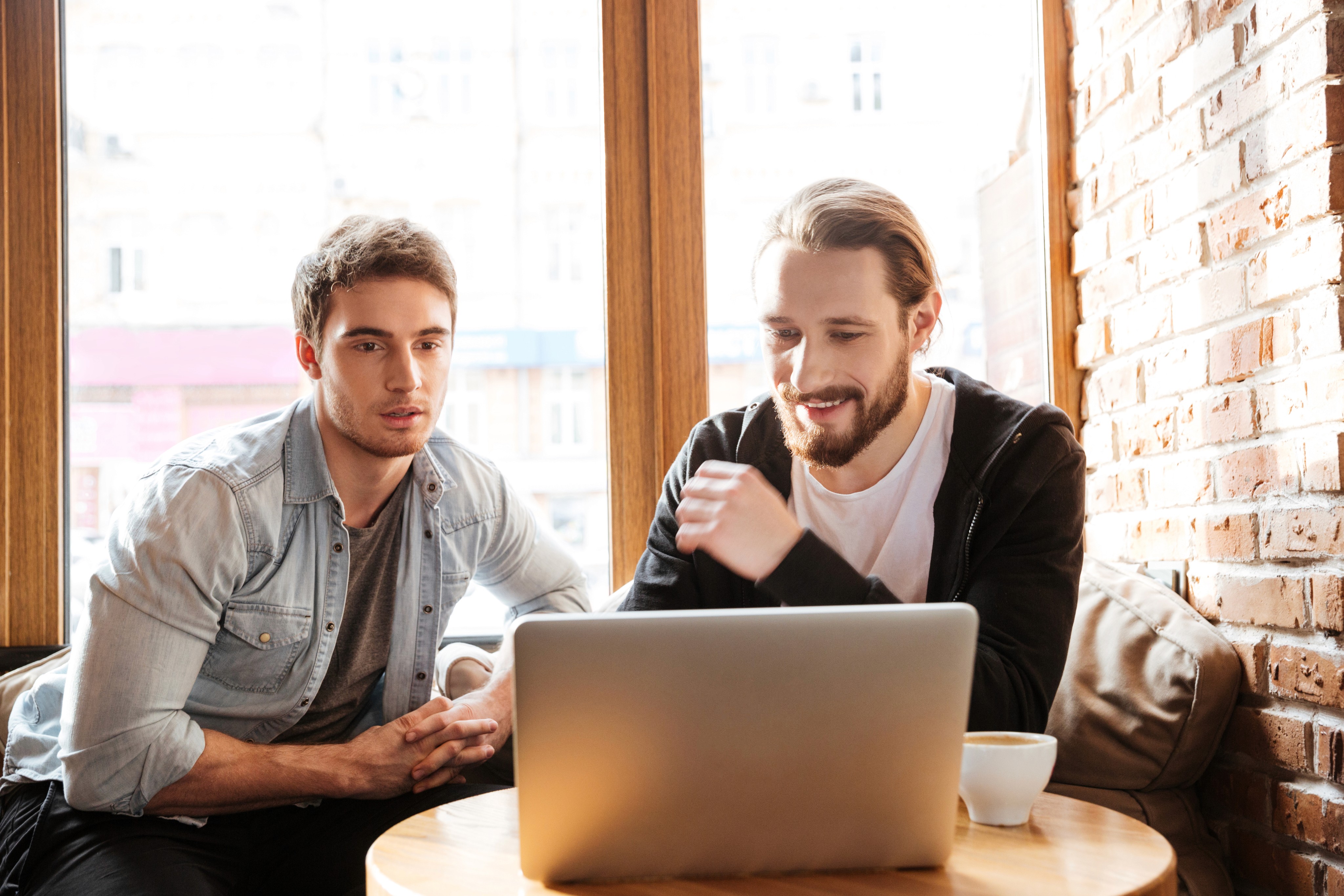 Two young men working on a laptop in a café.      Like  Dislike