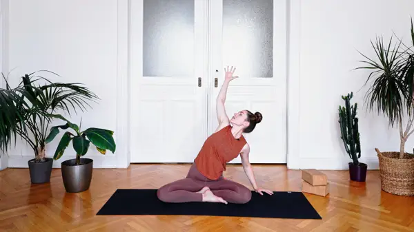 Pregnant woman in a low lunge yoga pose – prenatal yoga class to expand rib cage and create breathing space using Ujjayi breath techniques