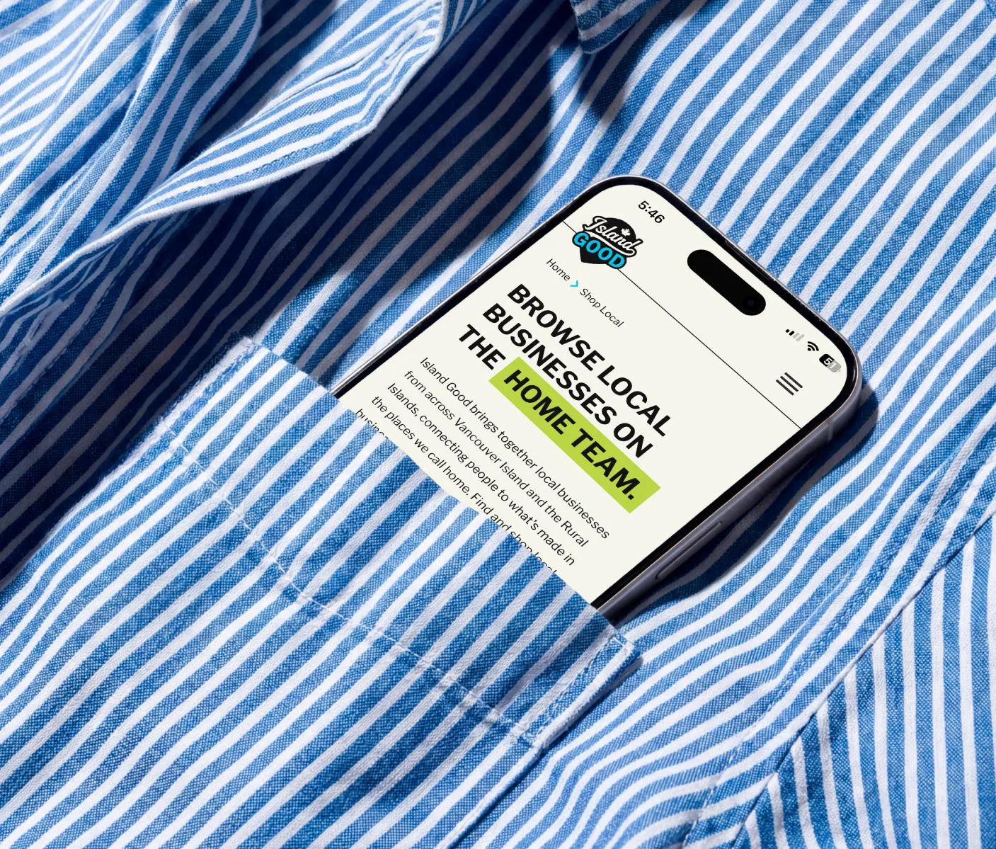 A cell phone in the front pocket of a blue and white striped shirt with the screen saying "Browse local businesses on the home team"