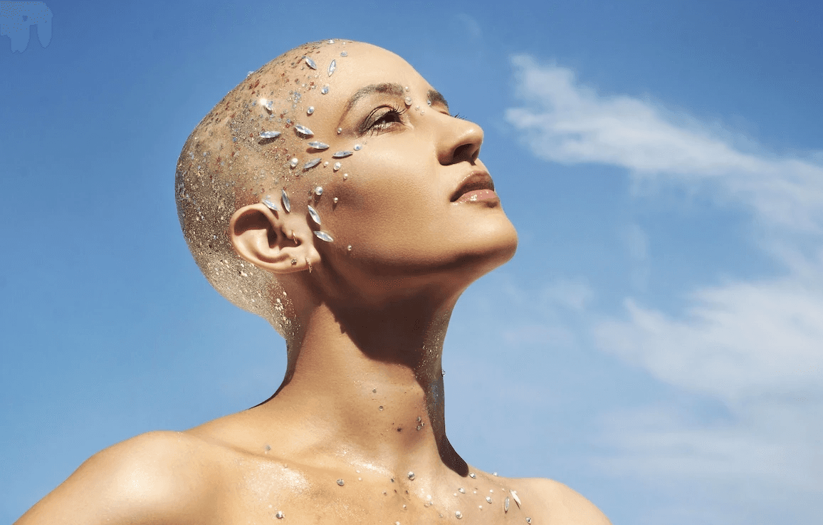 Portrait artistique mode éditorial, mannequin au visage orné de détails dorés sous ciel bleu