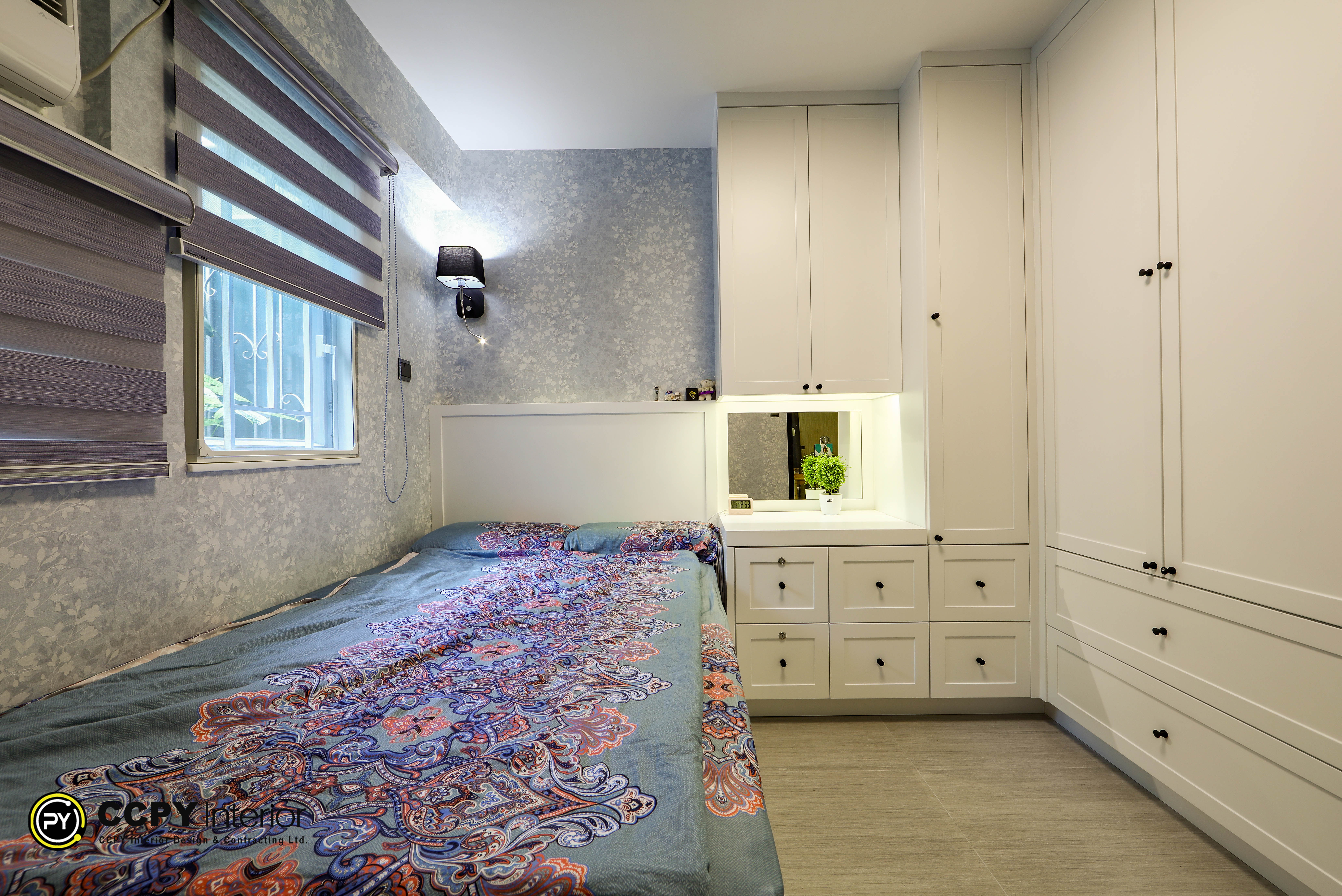 Bedroom interior showing white built-in storage cabinets, wood flooring, and soft overhead lighting in Kwan Lok Sun Chuen residence.
