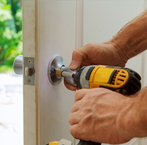 locksmith installing a lock with a power tool